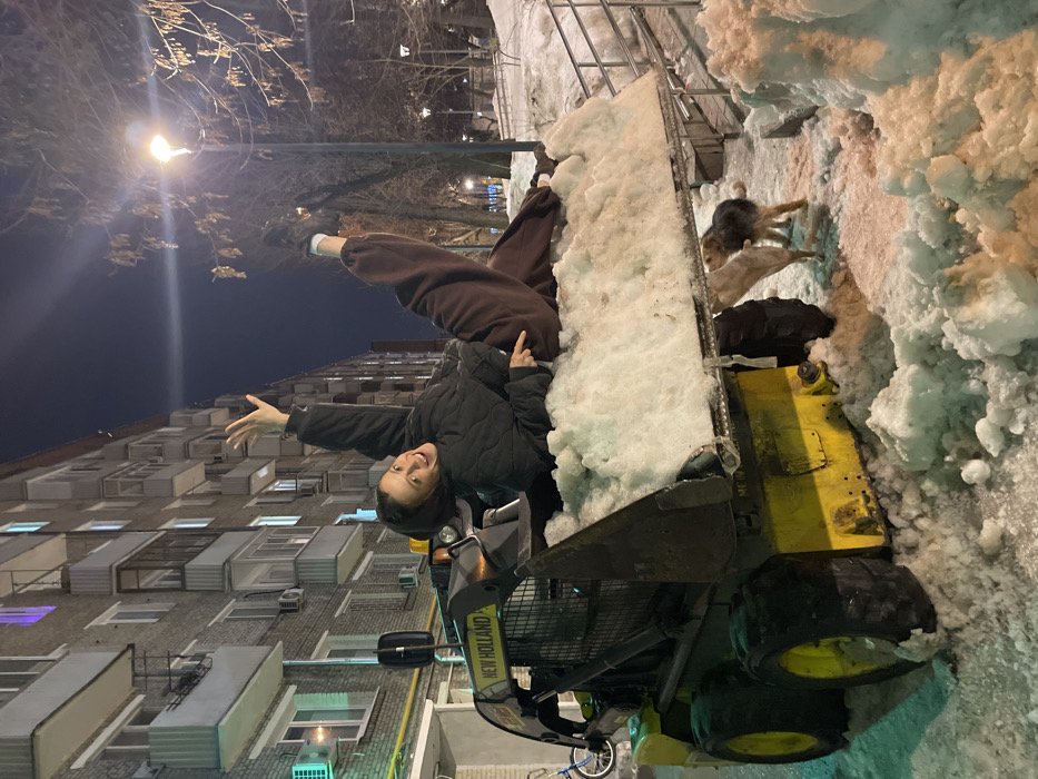 Woman poses on snow-filled loader in Moscow winter scene