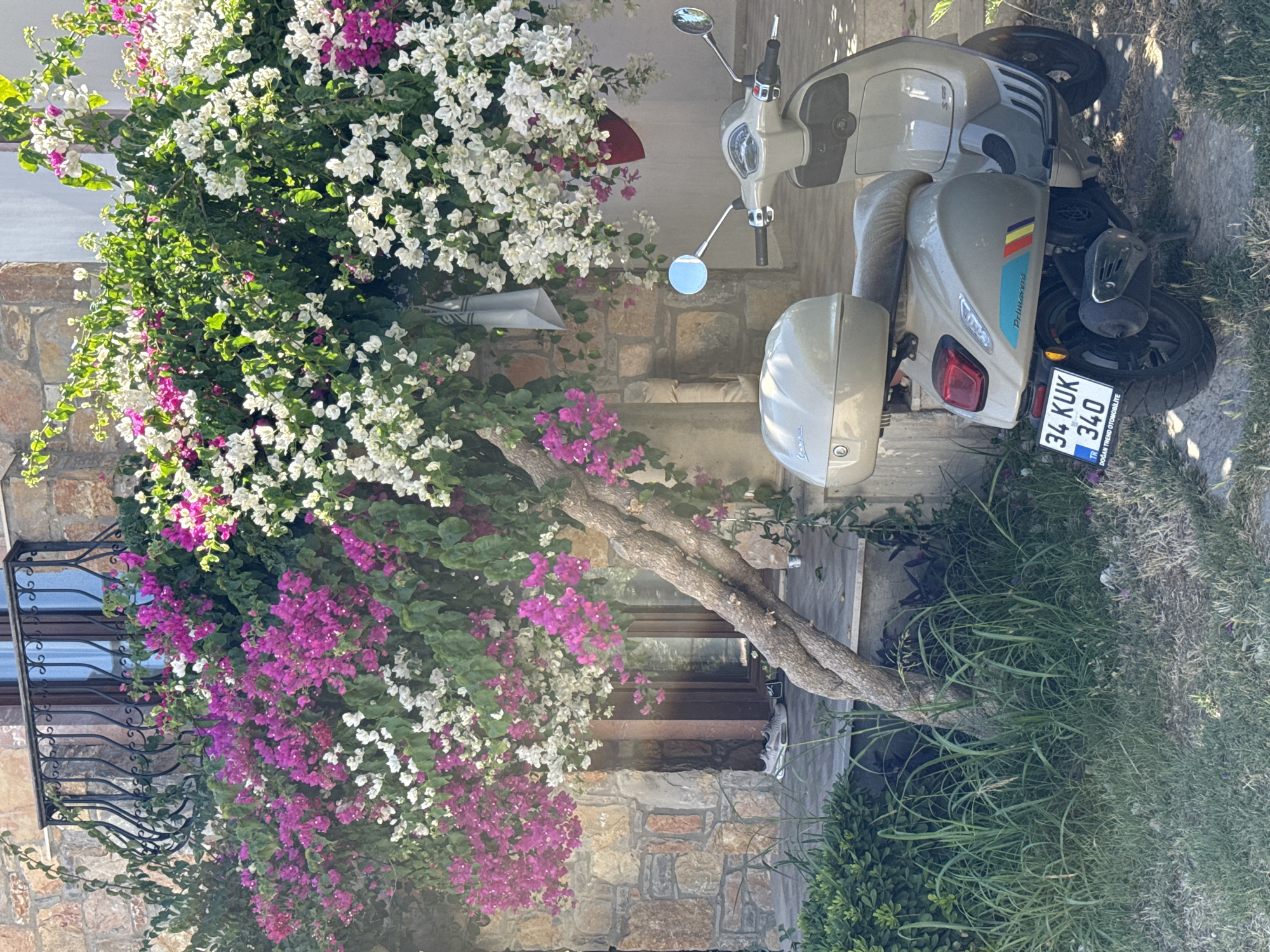 Selfie and parked Vespa outside a stone building in Bodrum