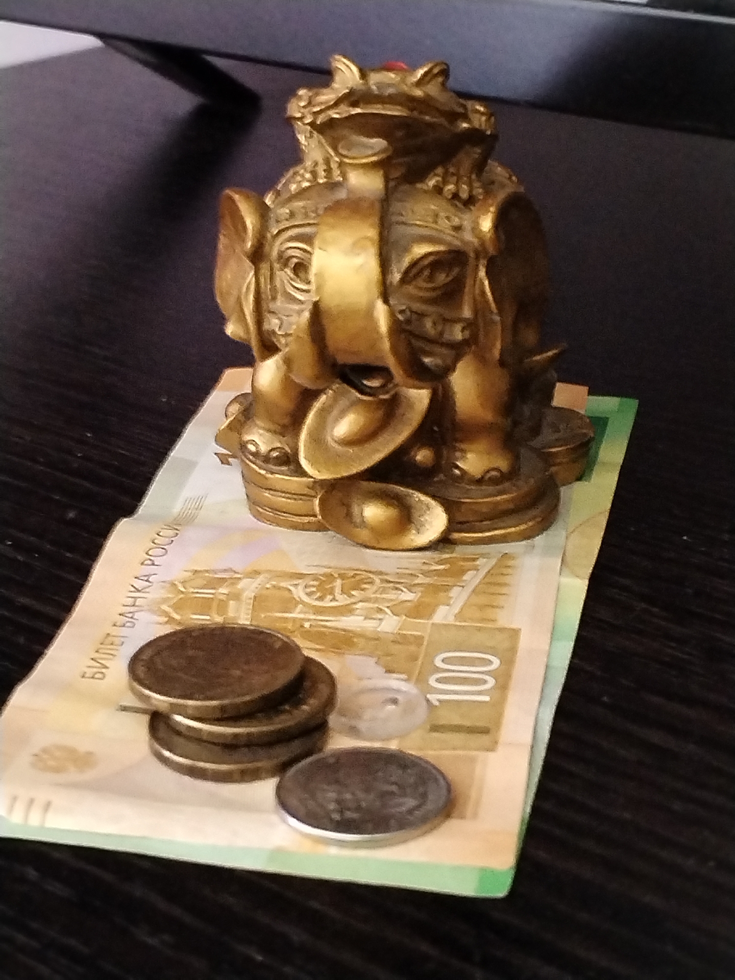 Elephant figurine on rubles and an apartment block from above