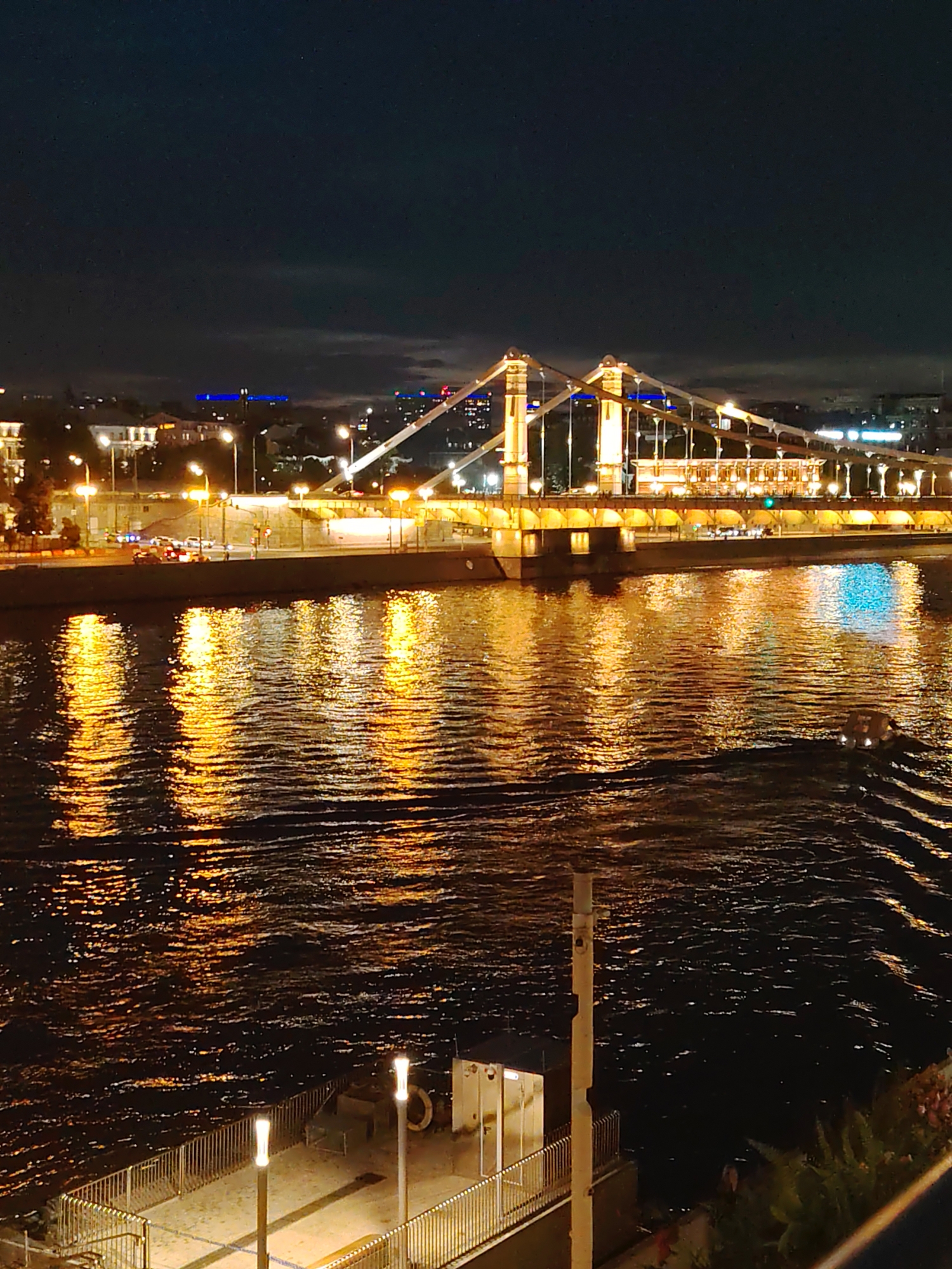 Nighttime along the Moskva River, lit boats and glowing bridges