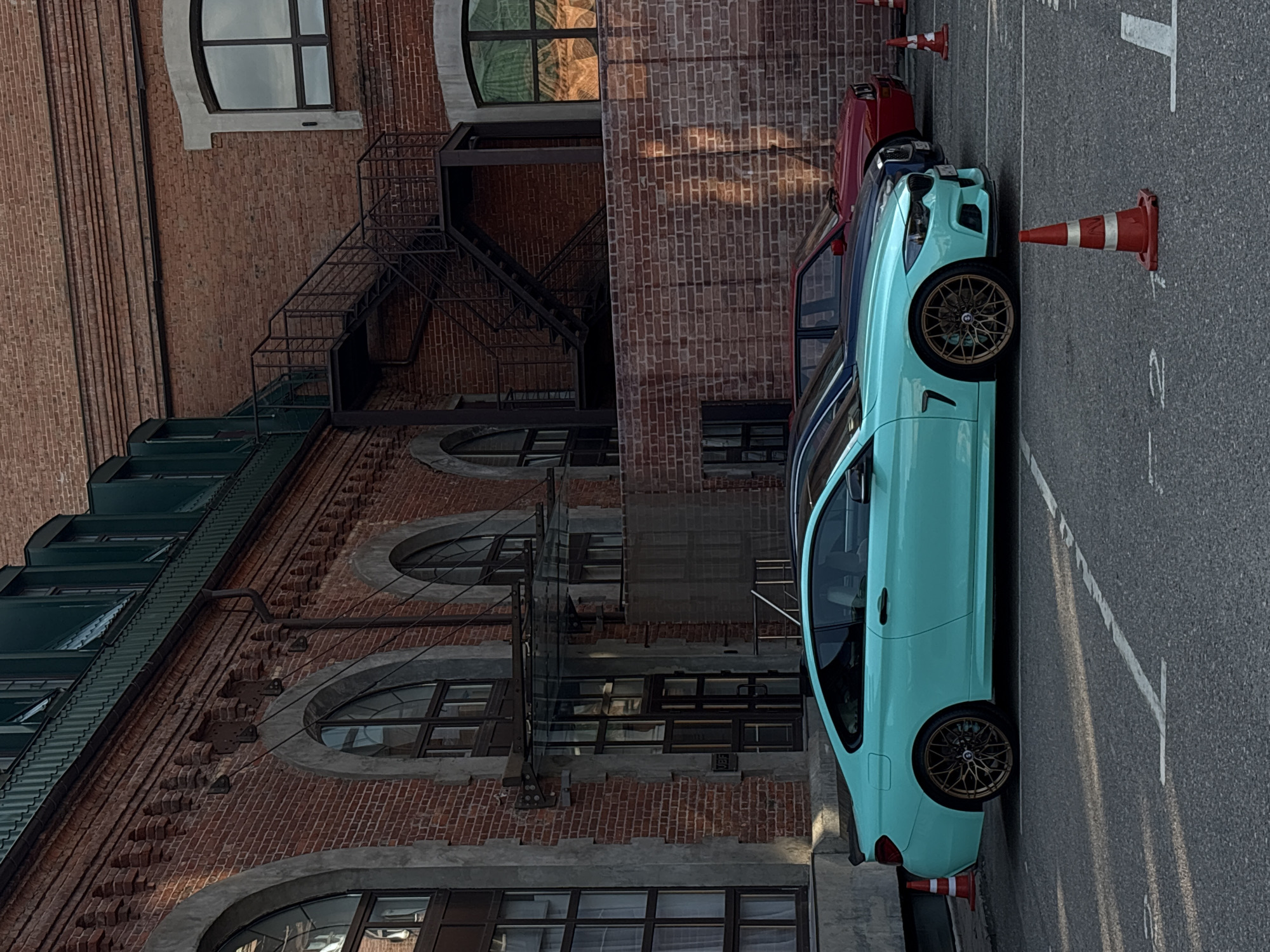 Red brick Moscow block, parking lot, and a teal BMW