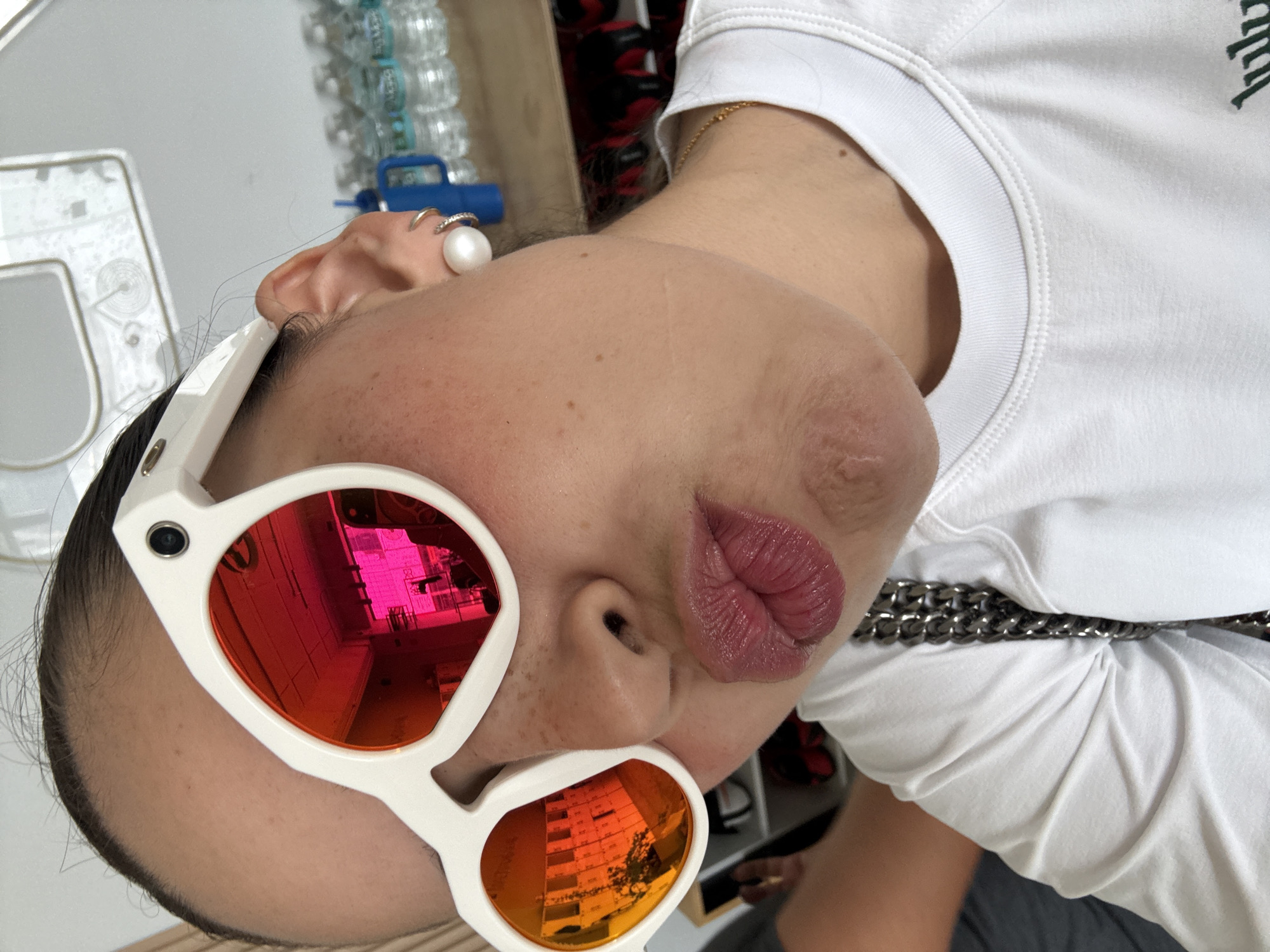 Woman takes selfie in Puebla shop wearing colorful sunglasses