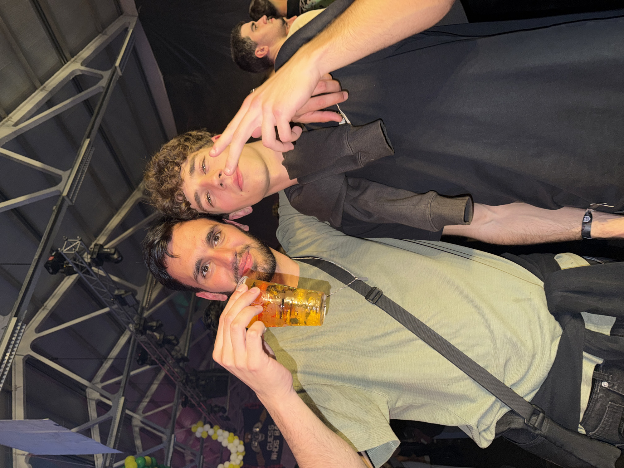 Three men pose with drinks at Bragança indoor event
