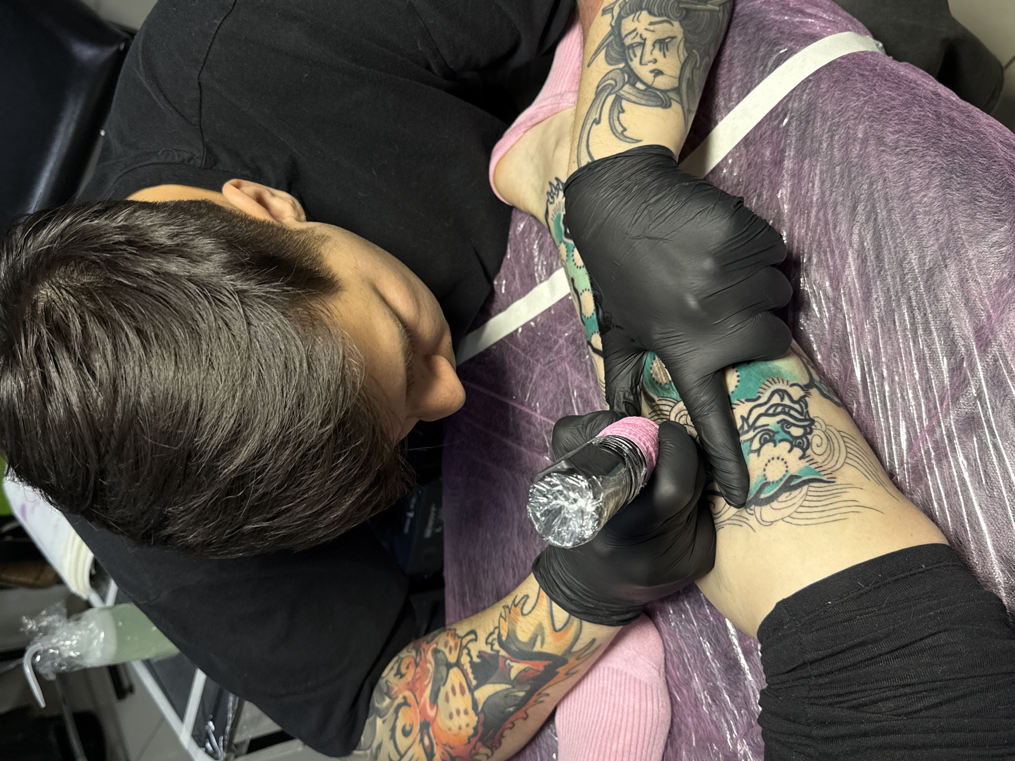 Tattoo artist works on client in Rostov-on-Don
