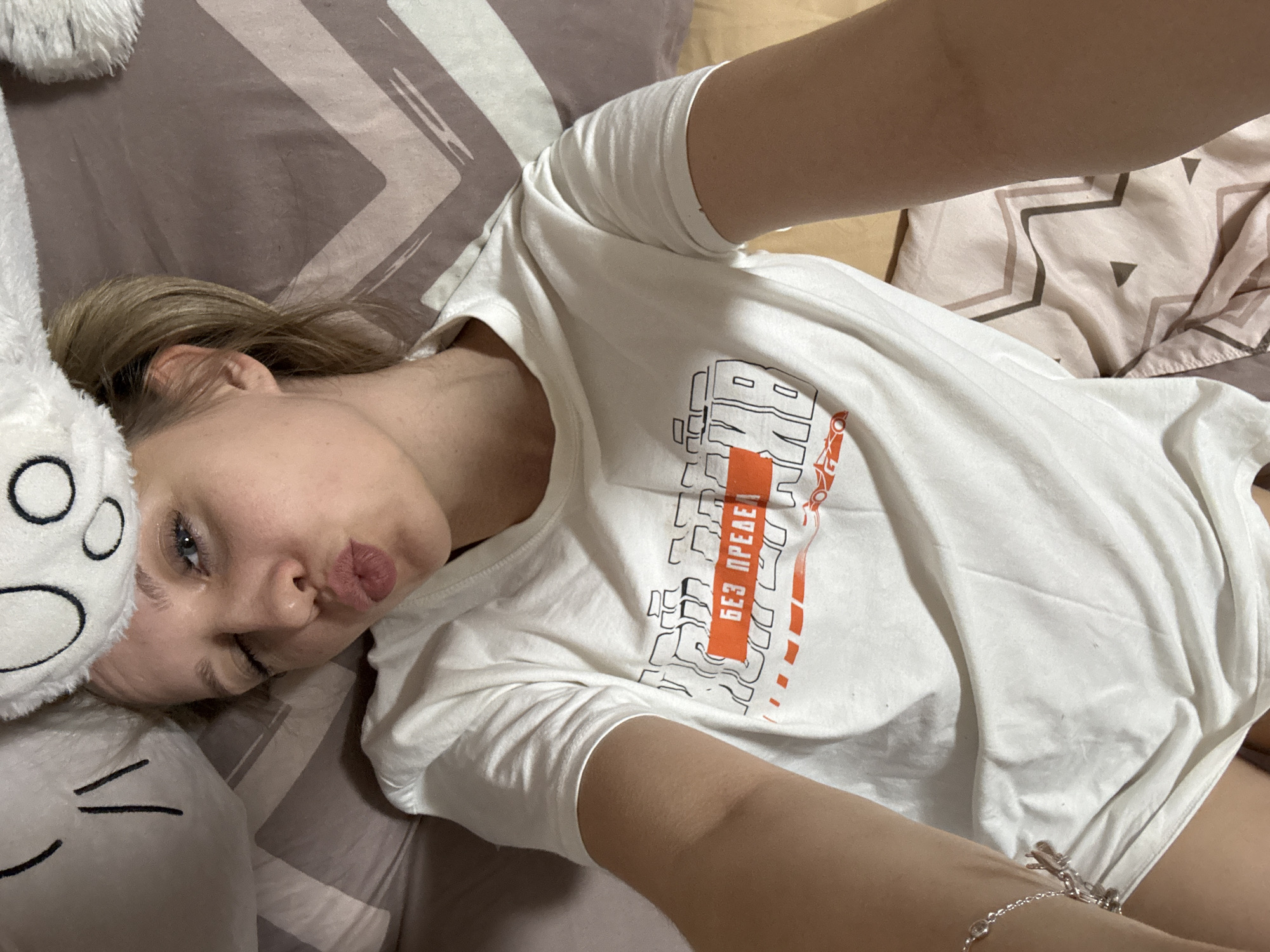 Woman takes selfies while petting rabbit indoors