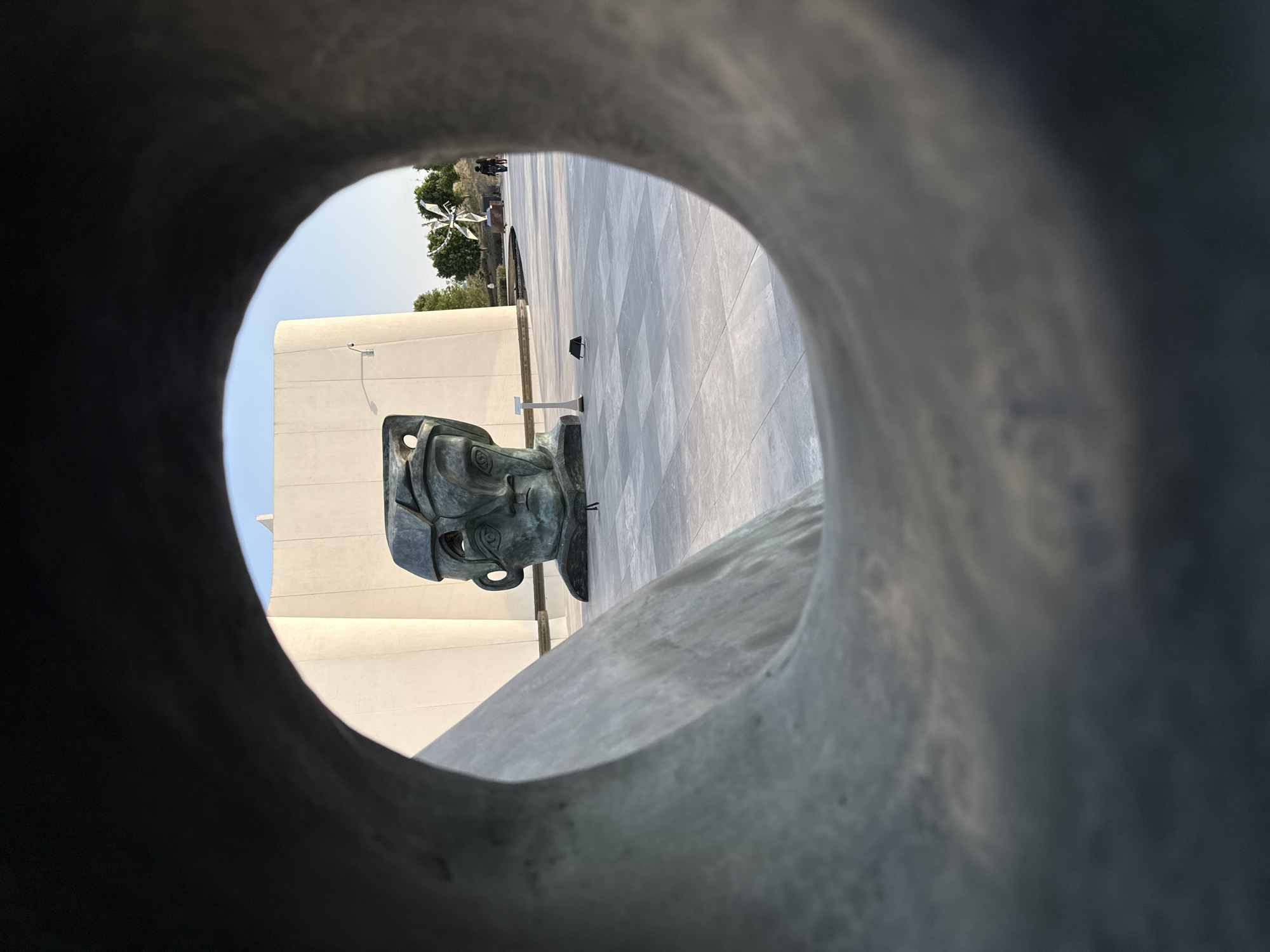 Bronze head sculpture observed through circular frame in Mexico