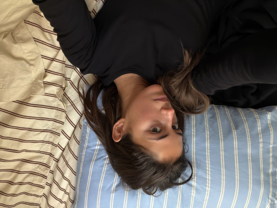 Woman resting on bed observed in Paris indoor location