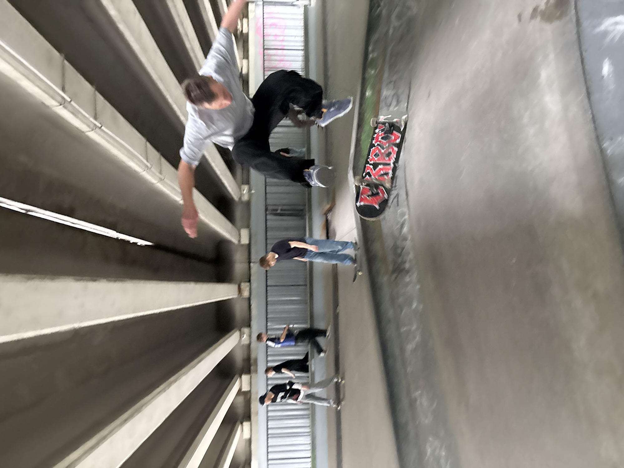 Skaters and a cyclist session an underpass skatepark in St. Petersburg