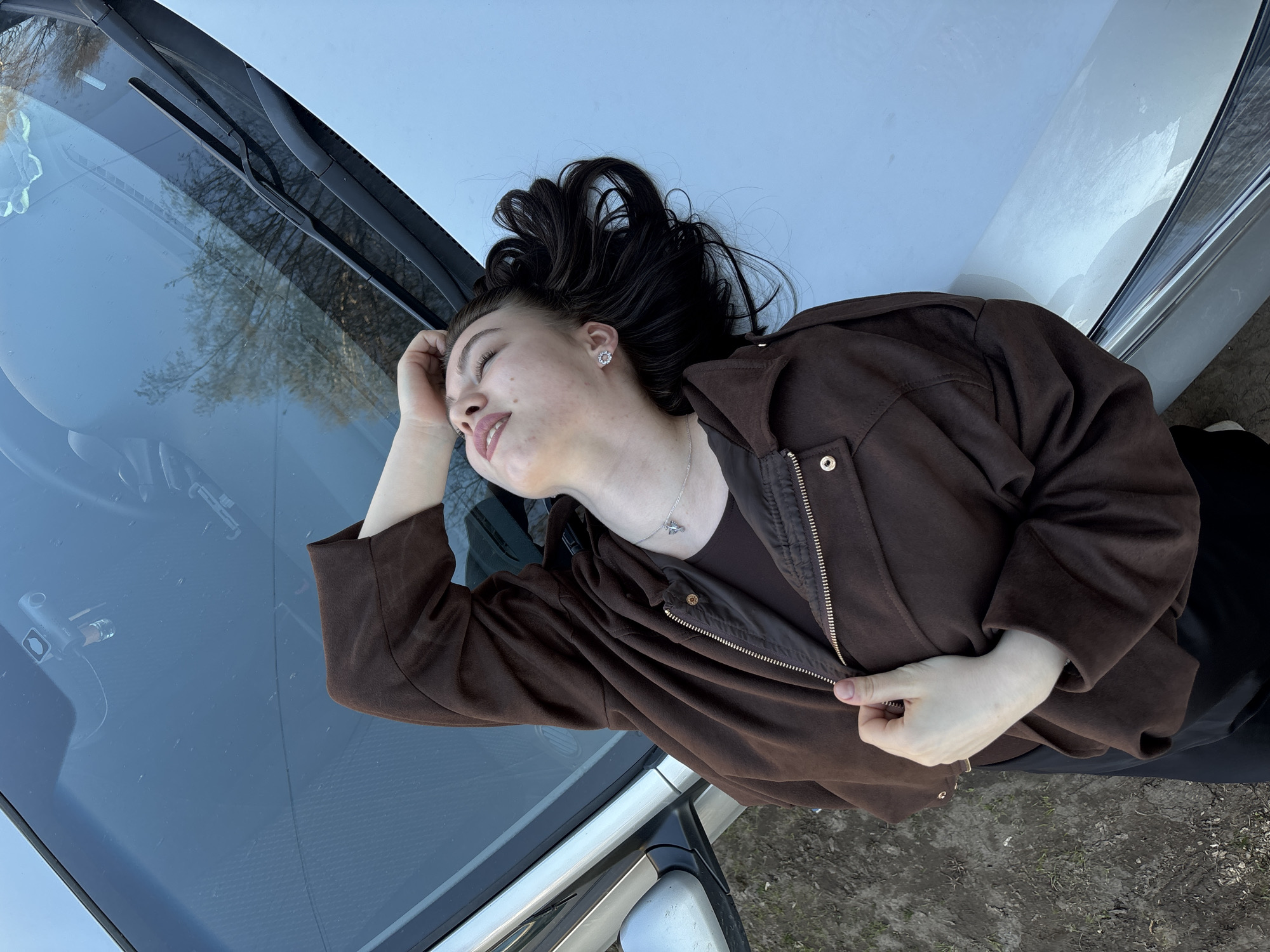 Woman rests on car hood in Perm, Russia