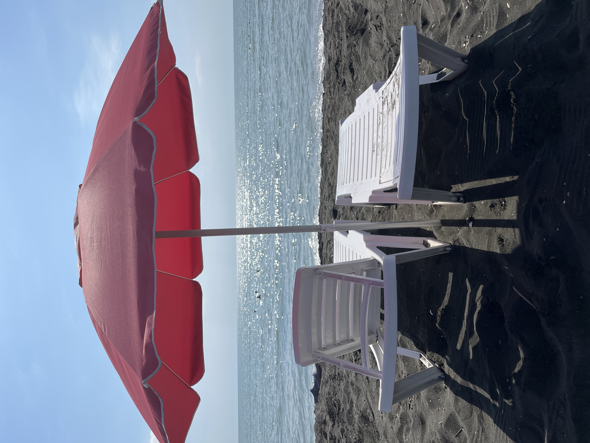 Ureki's black sand beach: chairs, shells, and shoreline details