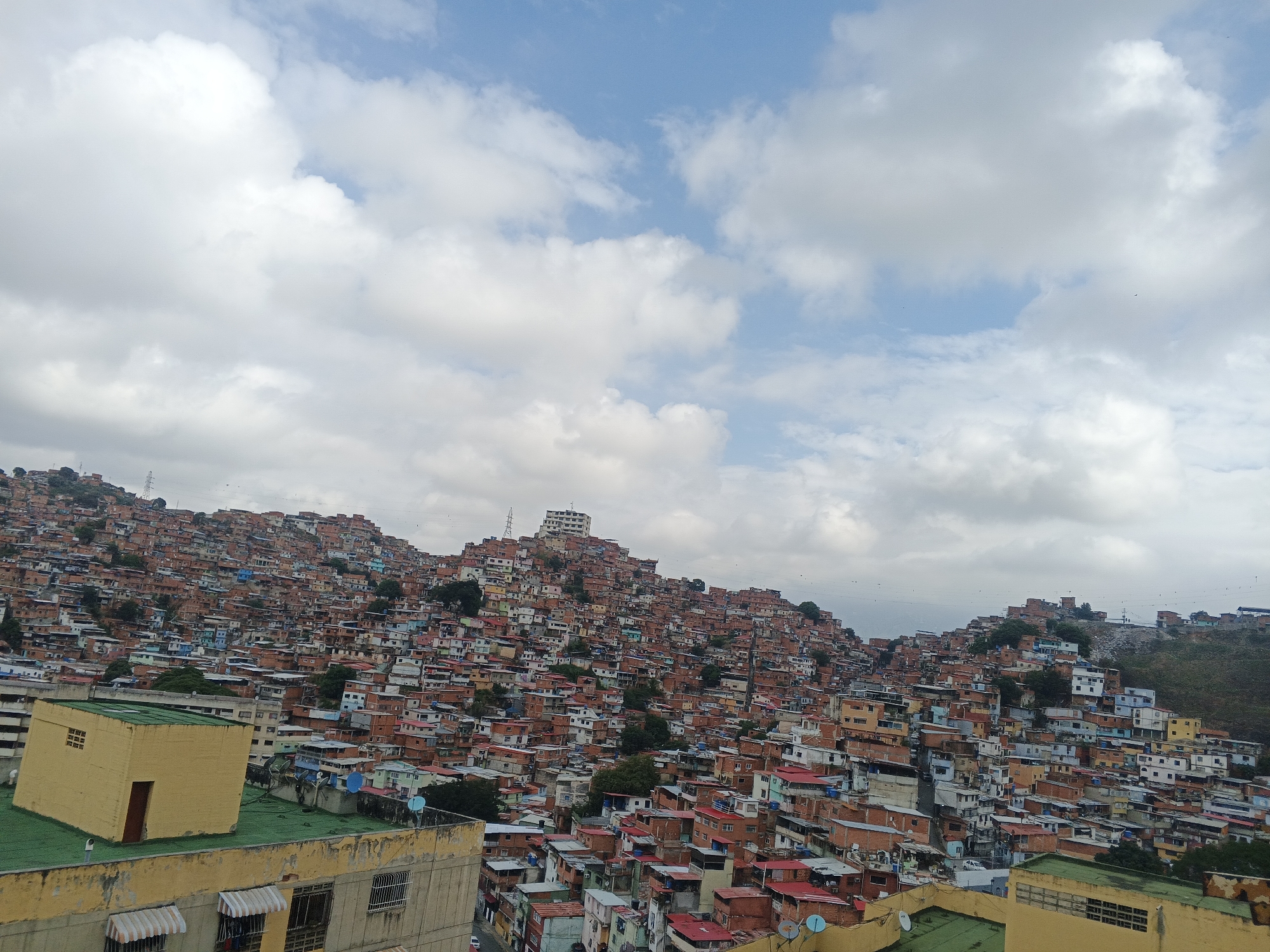 Hillside favela documented in Caracas under partly cloudy skies