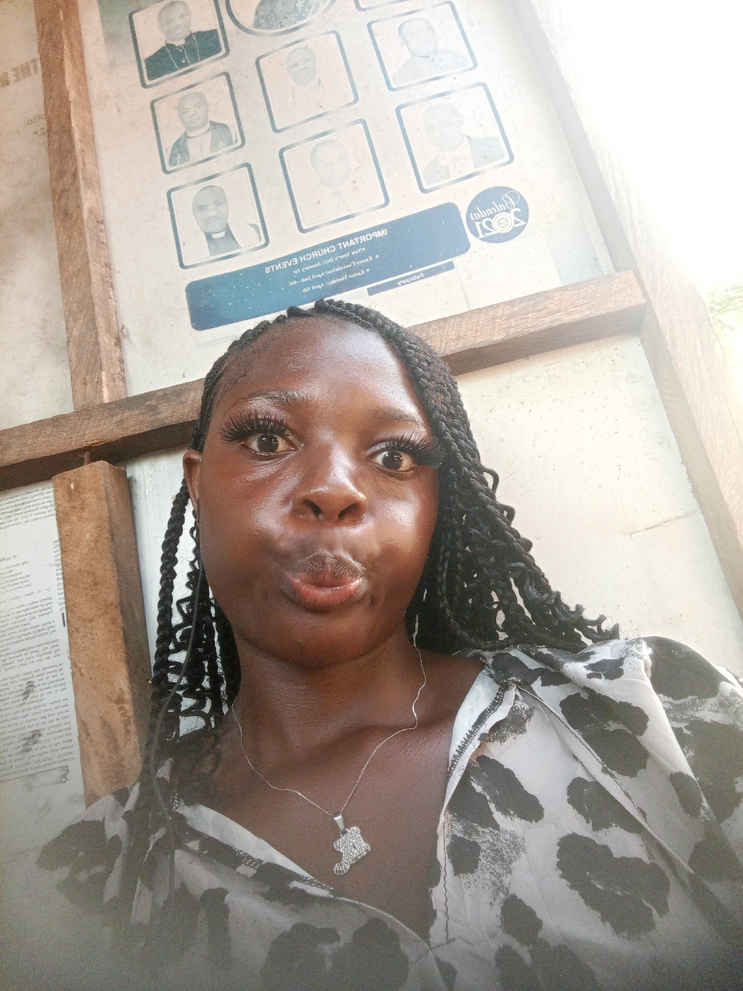 Woman views portrait notice board in Mbribit, Nigeria