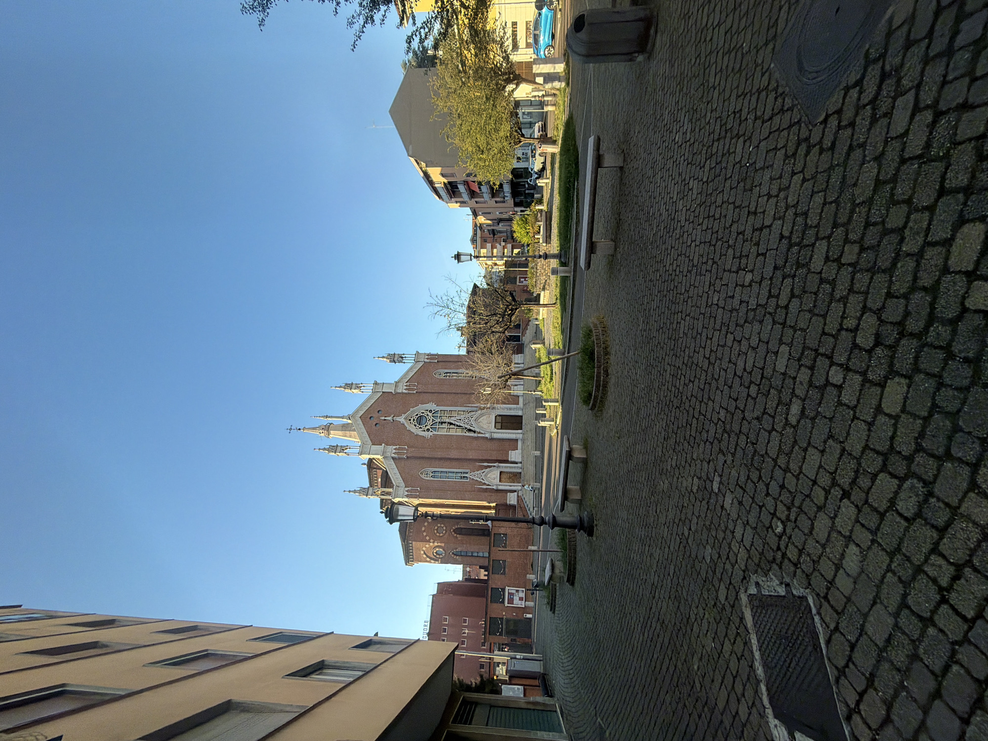 Gothic brick church in Novara under a clear blue sky