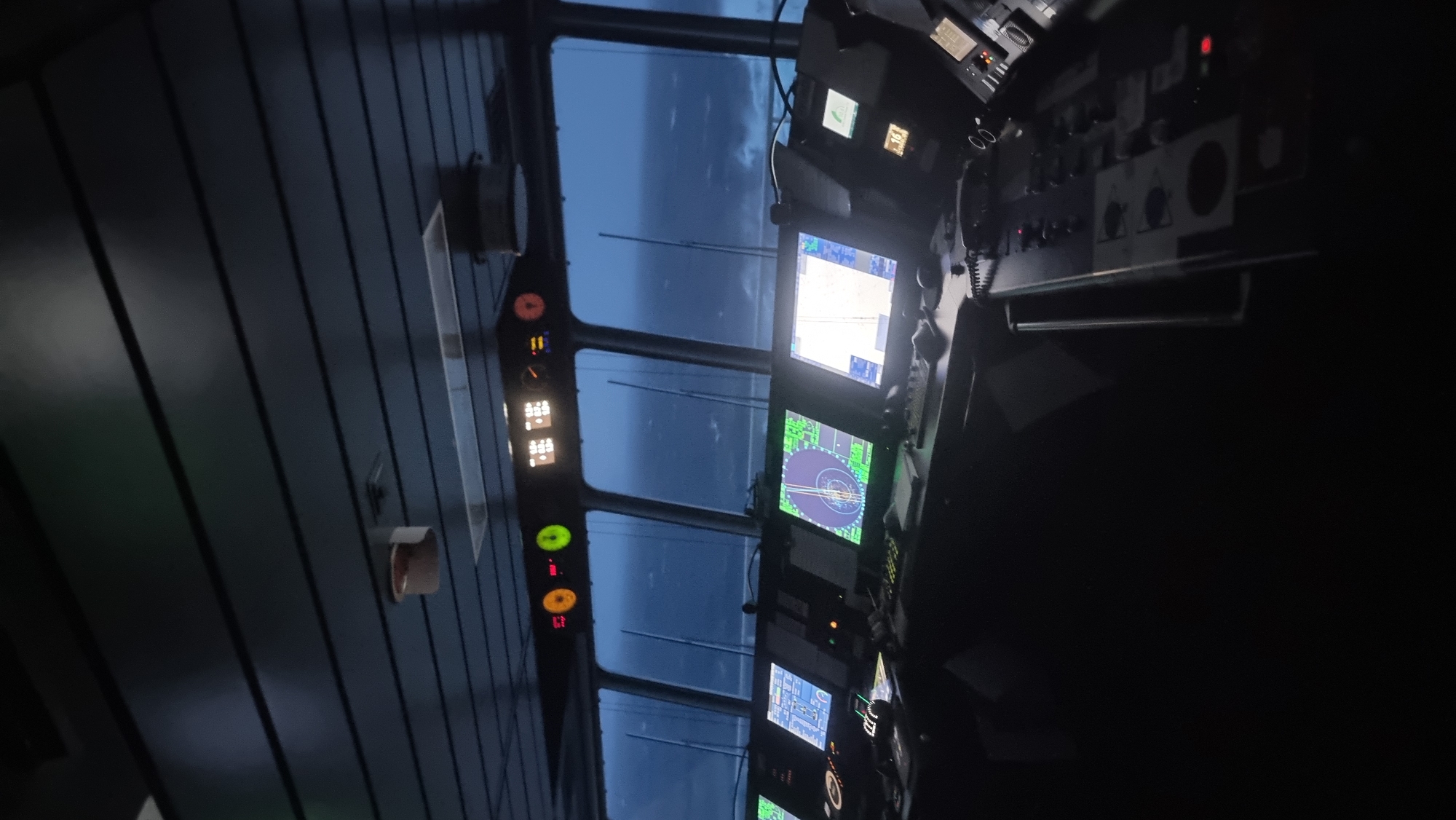 Ship's bridge navigating stormy seas, displays active