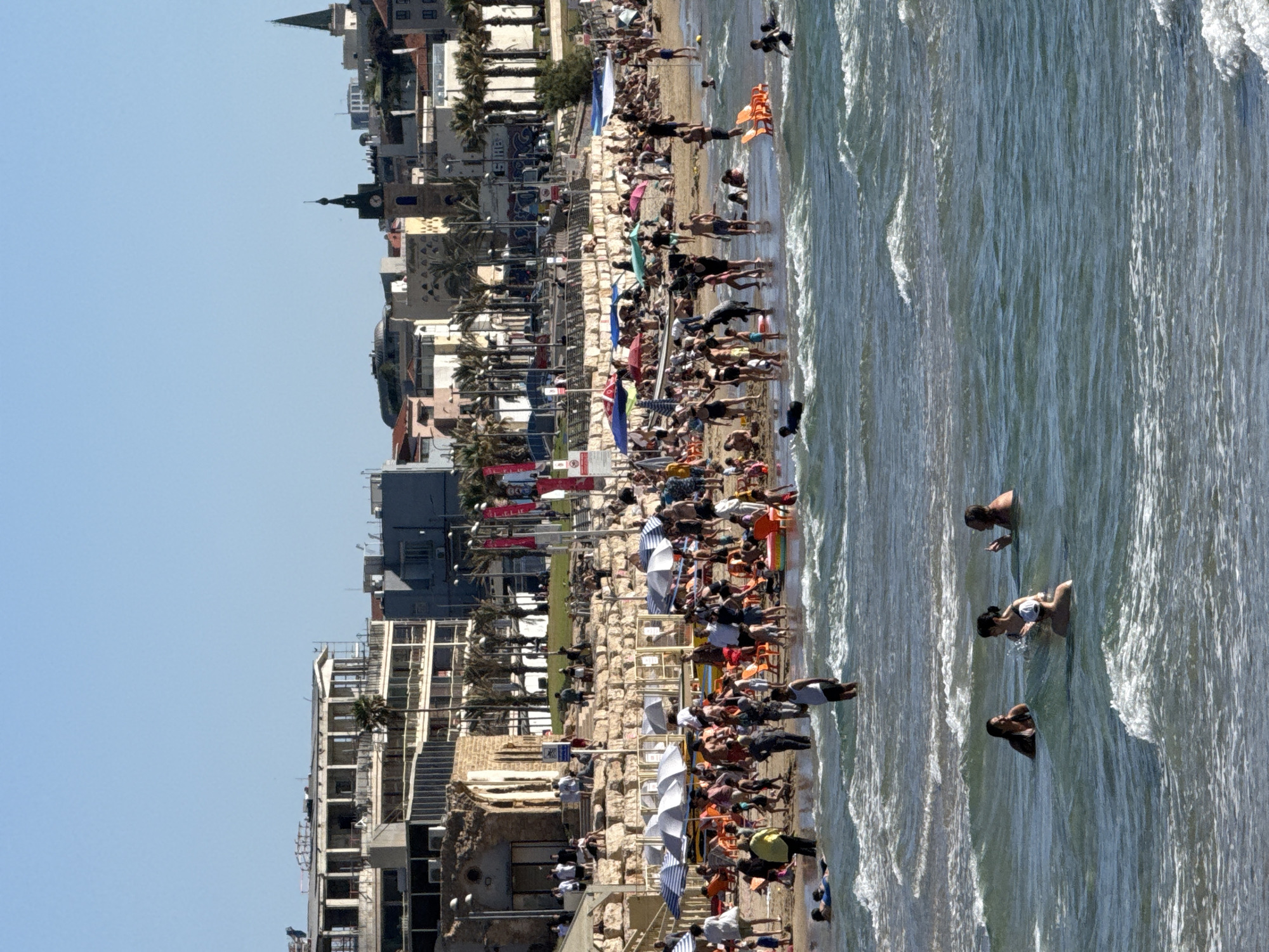Busy summer beach day draws crowds to Tel Aviv waters