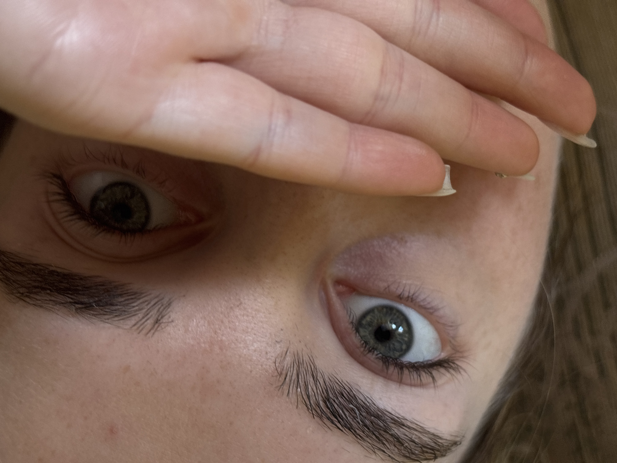 Close-up portrait captured with hand partially covering face