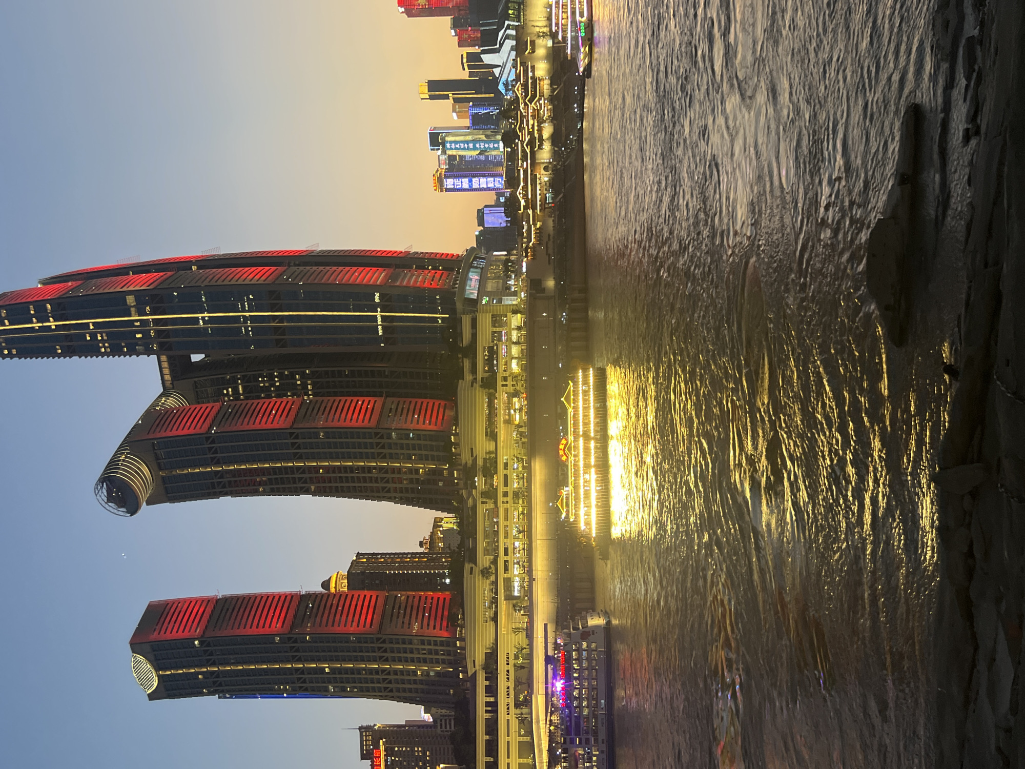 Chongqing riverfront skyline glowing at dusk
