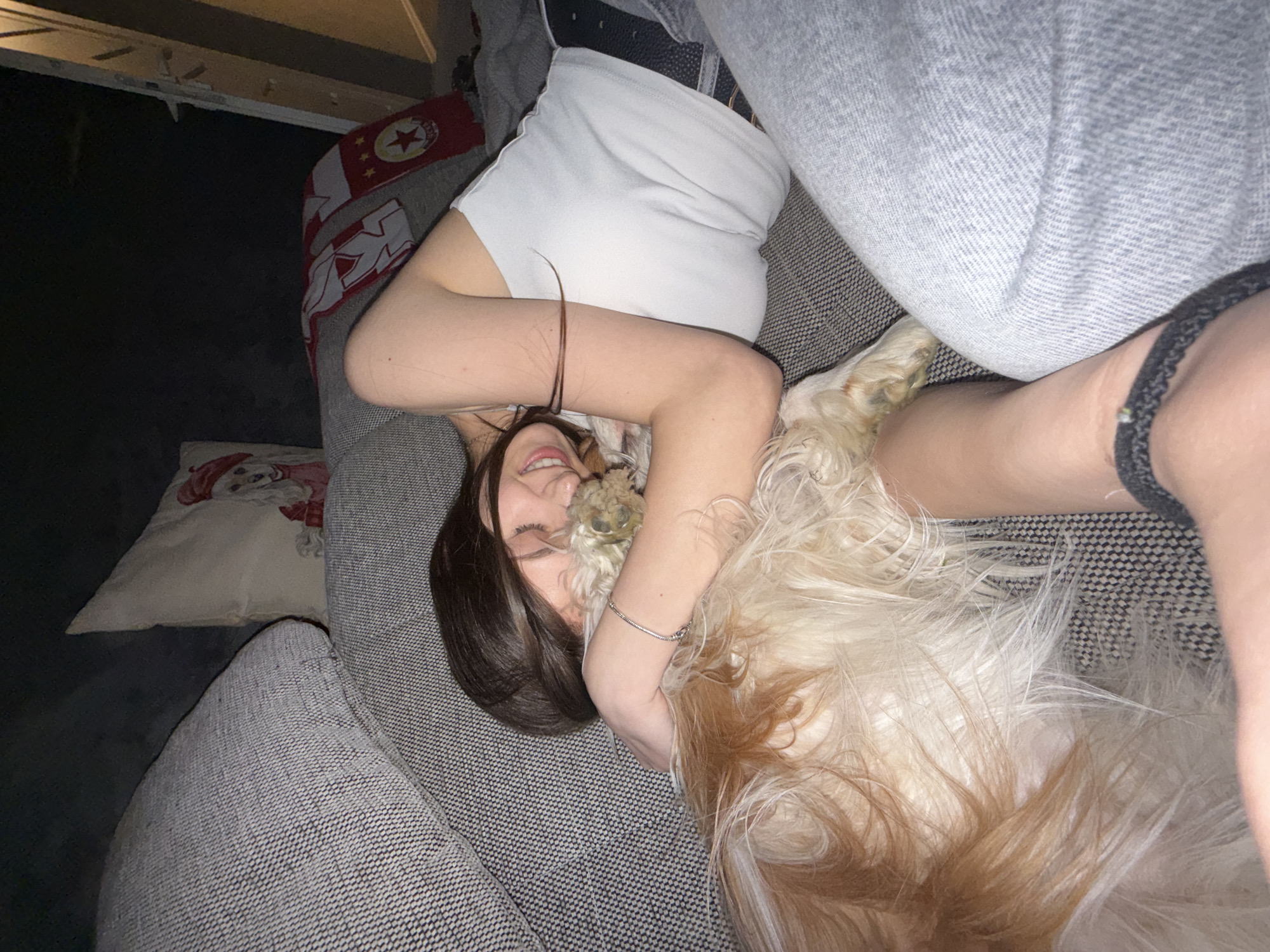 Woman cuddles with dog on sofa in Sofia