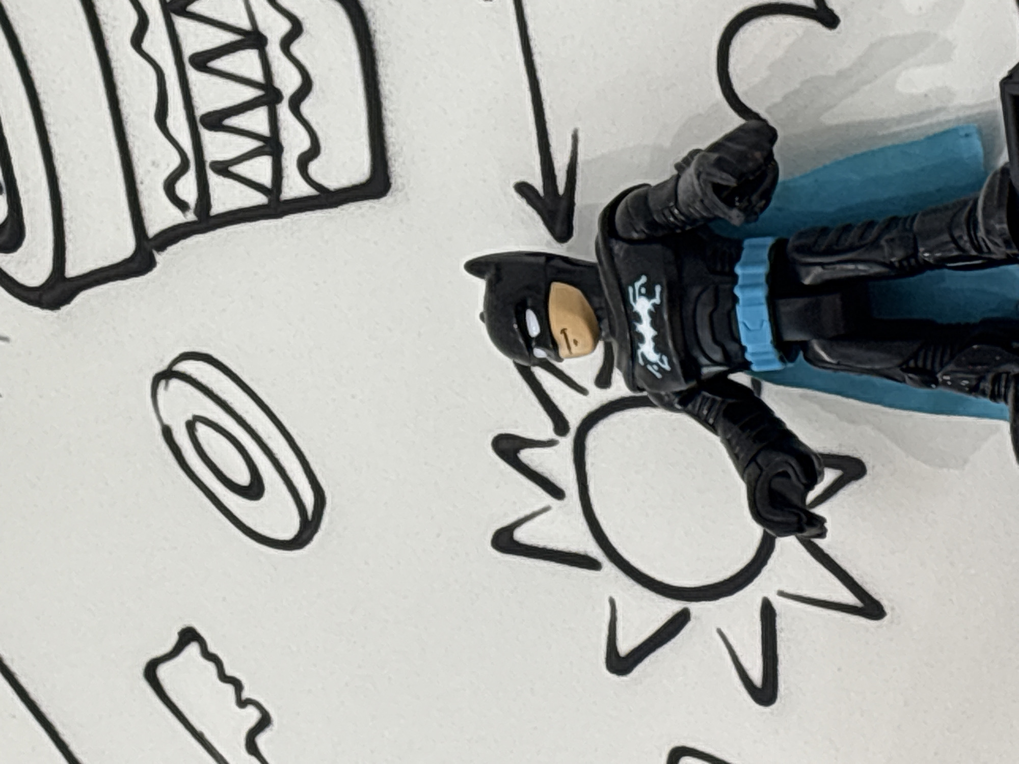 Artistic expressions and Batman figure documented at indoor location