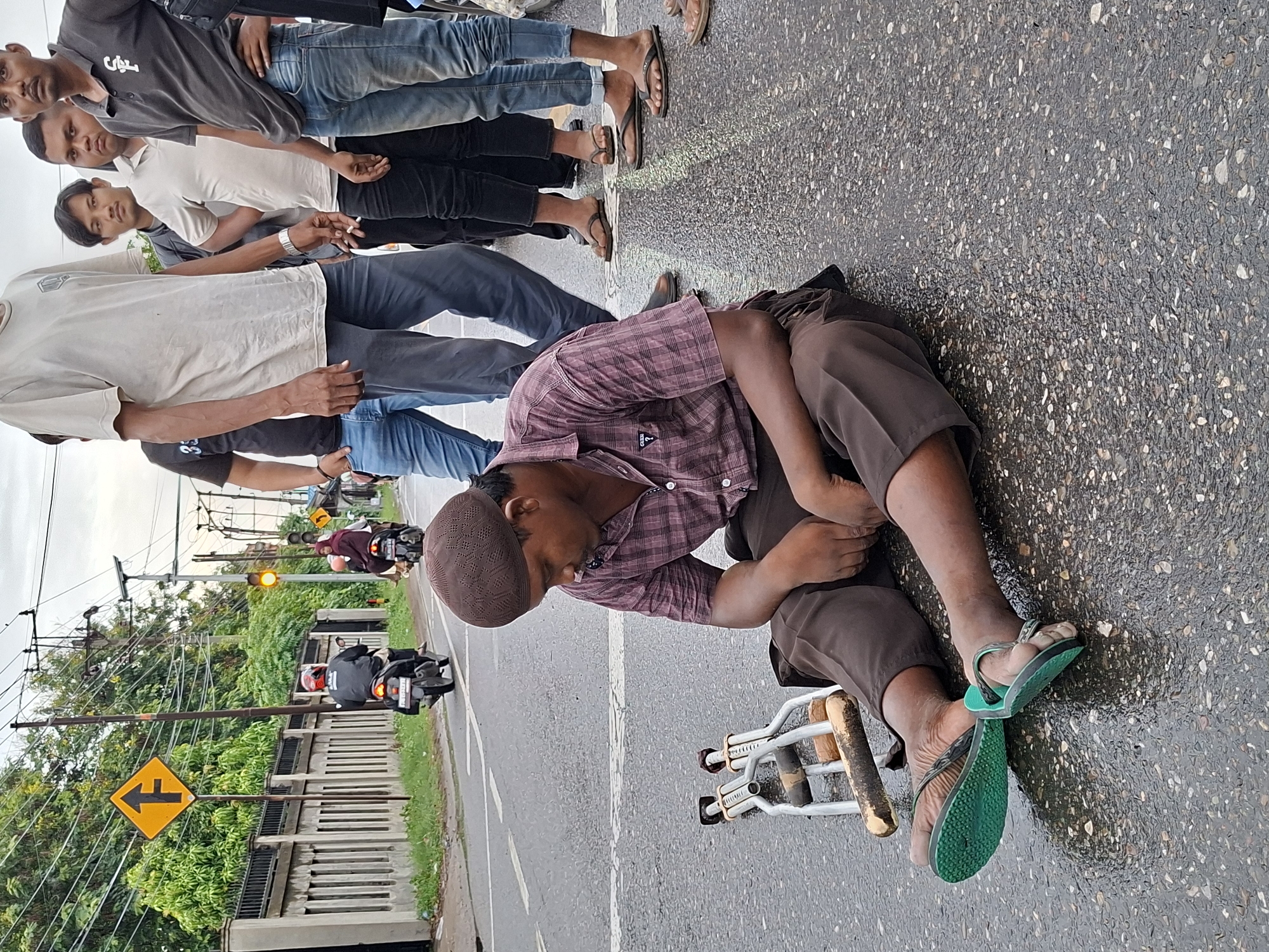 Man with crutches sits on street in Keudebayu