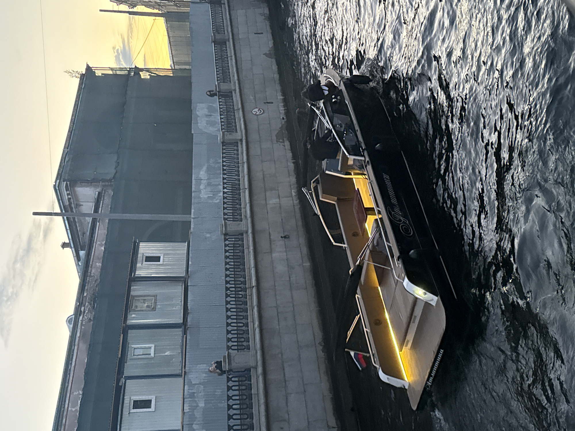 Evening canal traffic and street performances in Saint Petersburg