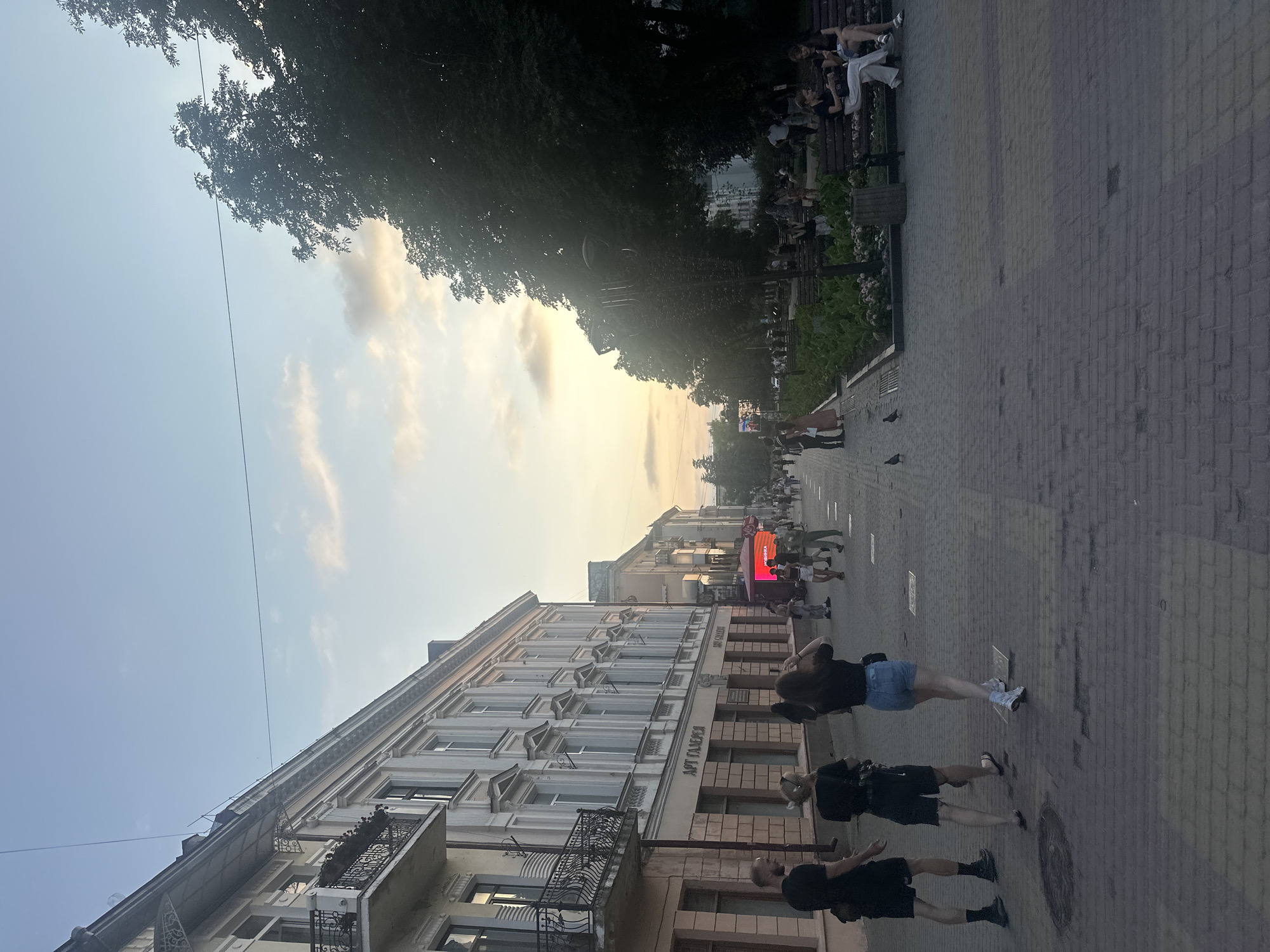 Sunset stroll through Ternopil's pedestrian center near a church