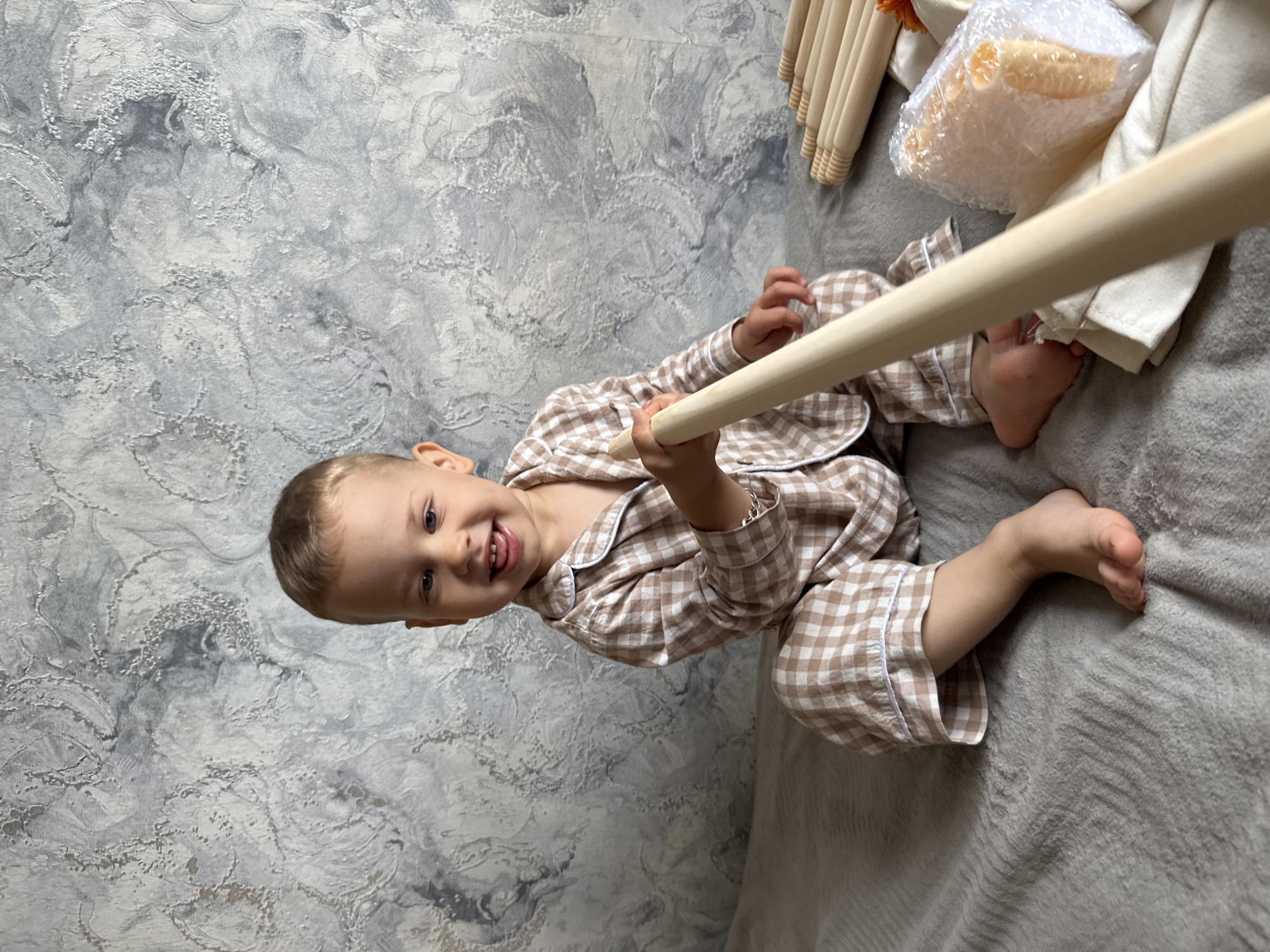Toddler plays with tent poles in morning pajamas