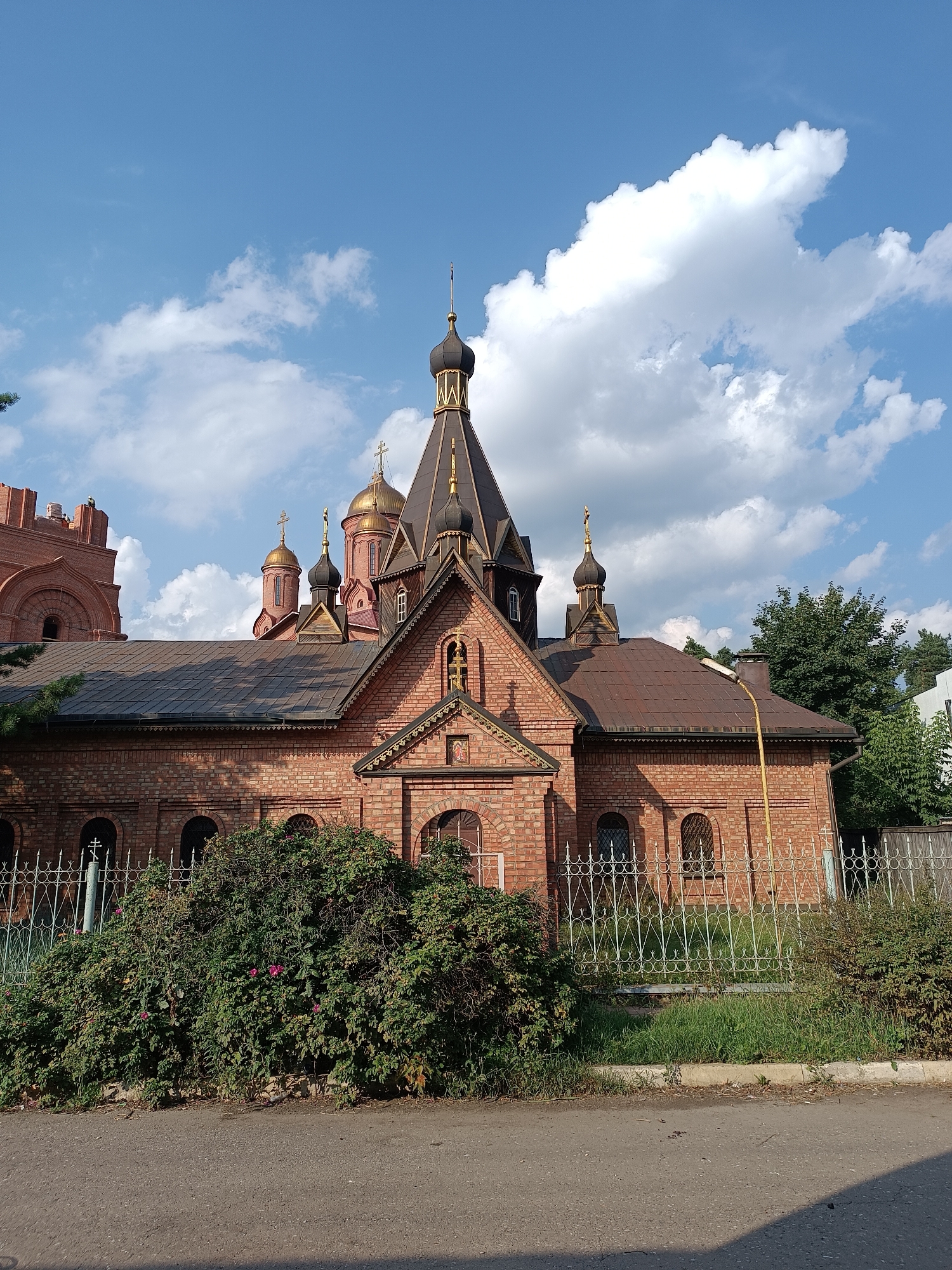 Red-domed Orthodox church in Il'inskiy seen from rail and ground