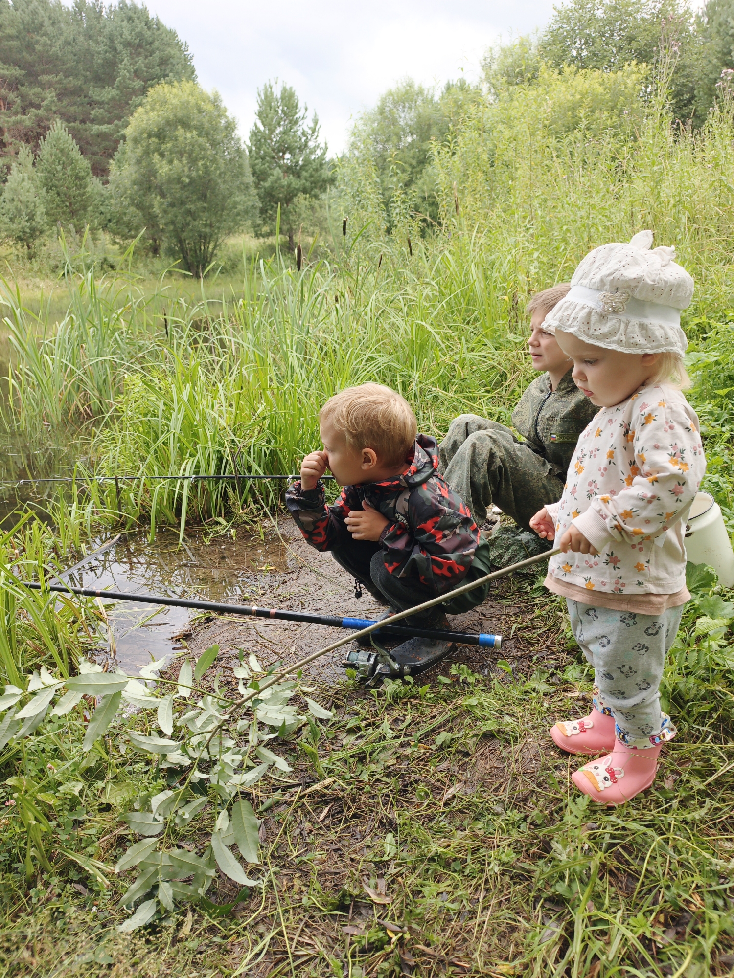 Kids fishing a rural Russian lake, wildflowers all around