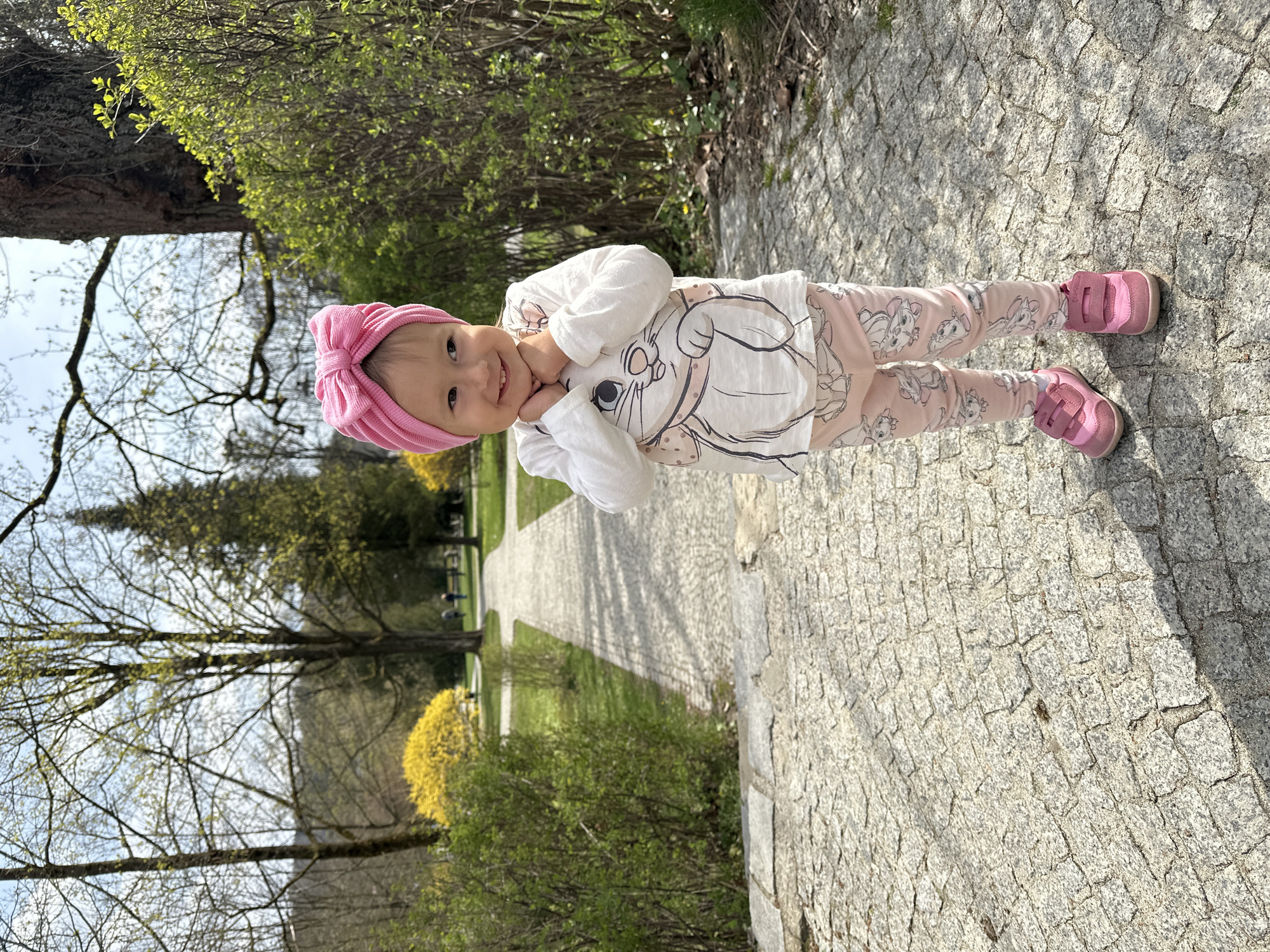 Child enjoys spring morning in Wisła park amid blooming shrubs