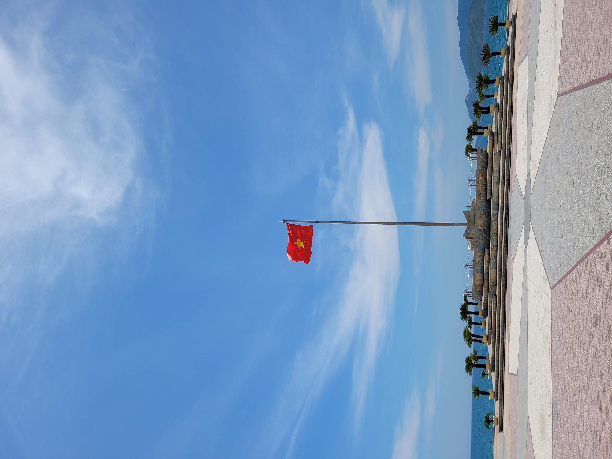 Coastal scenes with Vietnamese flag, buildings, decorated rickshaw captured