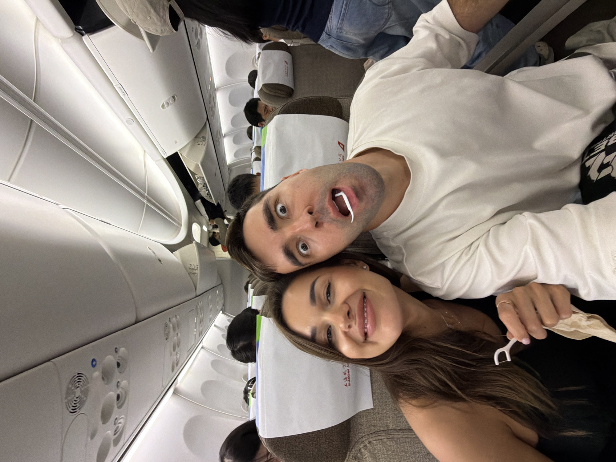 Airplane passengers take playful selfie with makeshift dental floss fangs