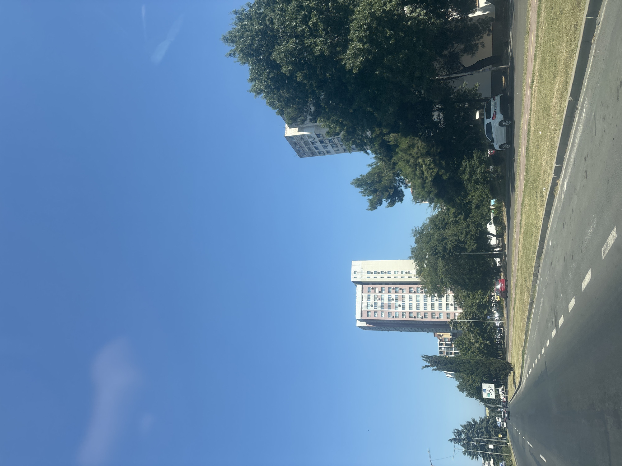Driving through sunny Burgas past flags and city streets