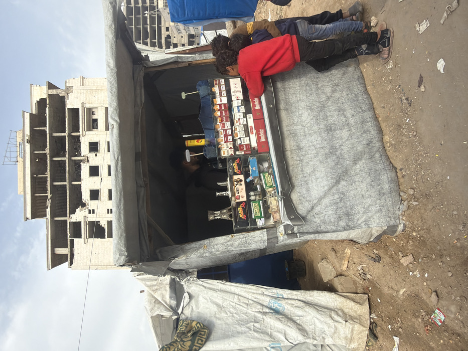 Vendor stall operates amid damaged buildings in Gaza