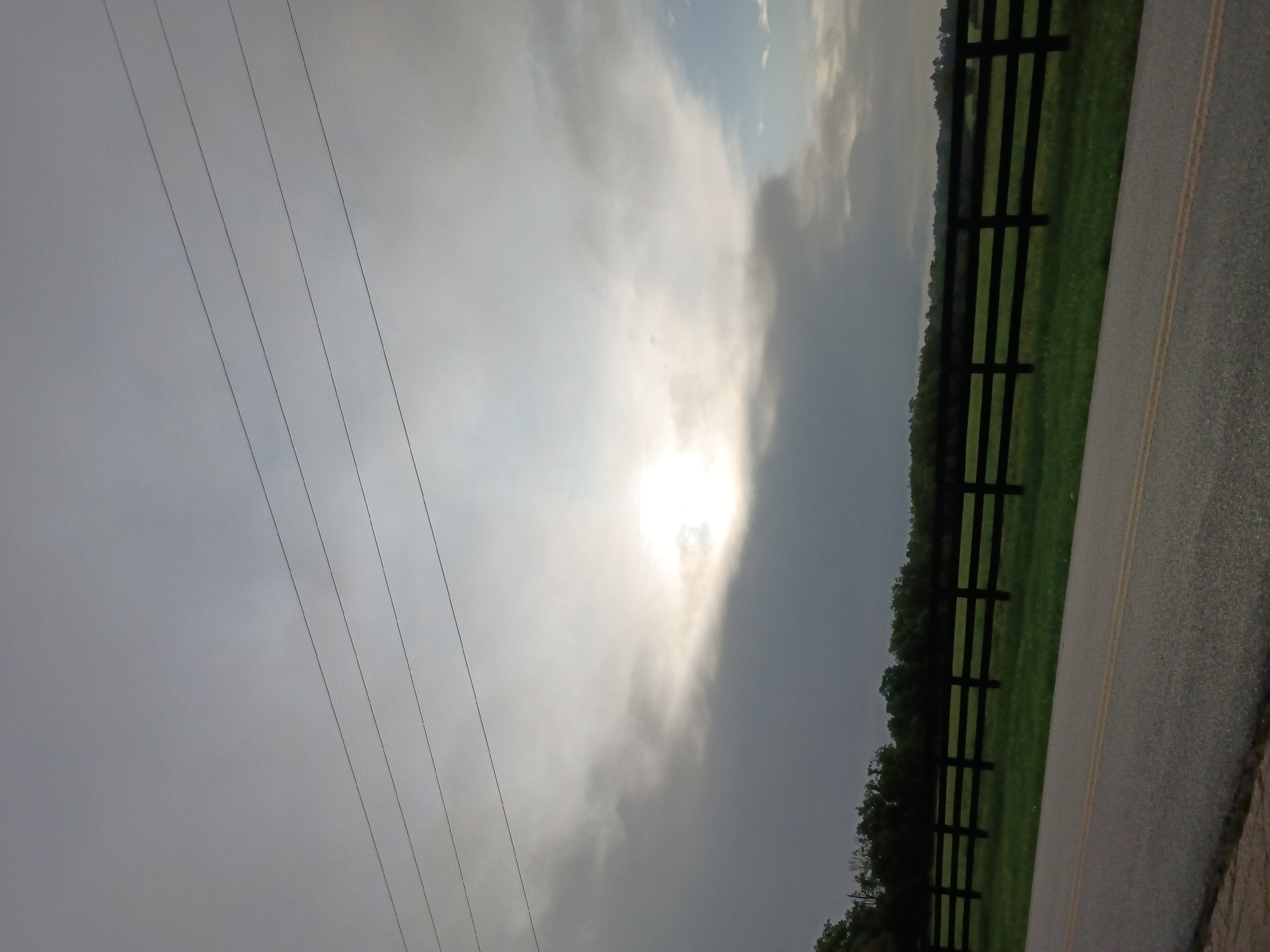 Fenced pasture road under cloudy skies, Versailles, Kentucky