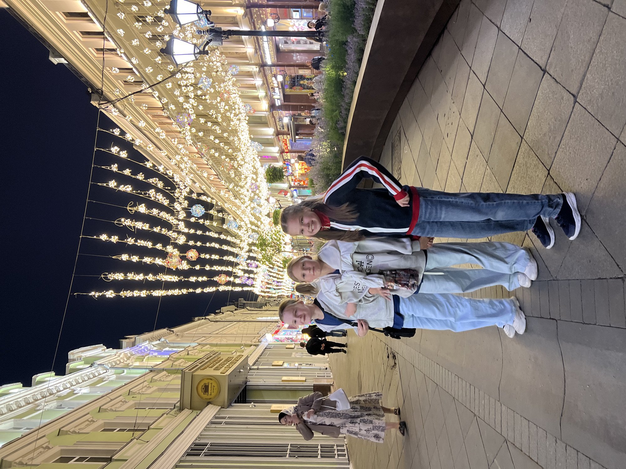 Evening street life in illuminated Moscow pedestrian area