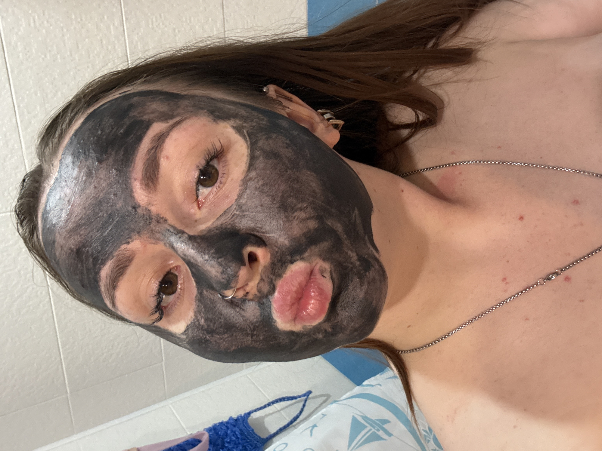 Woman documents self-care routine with facial mask, bubble bath