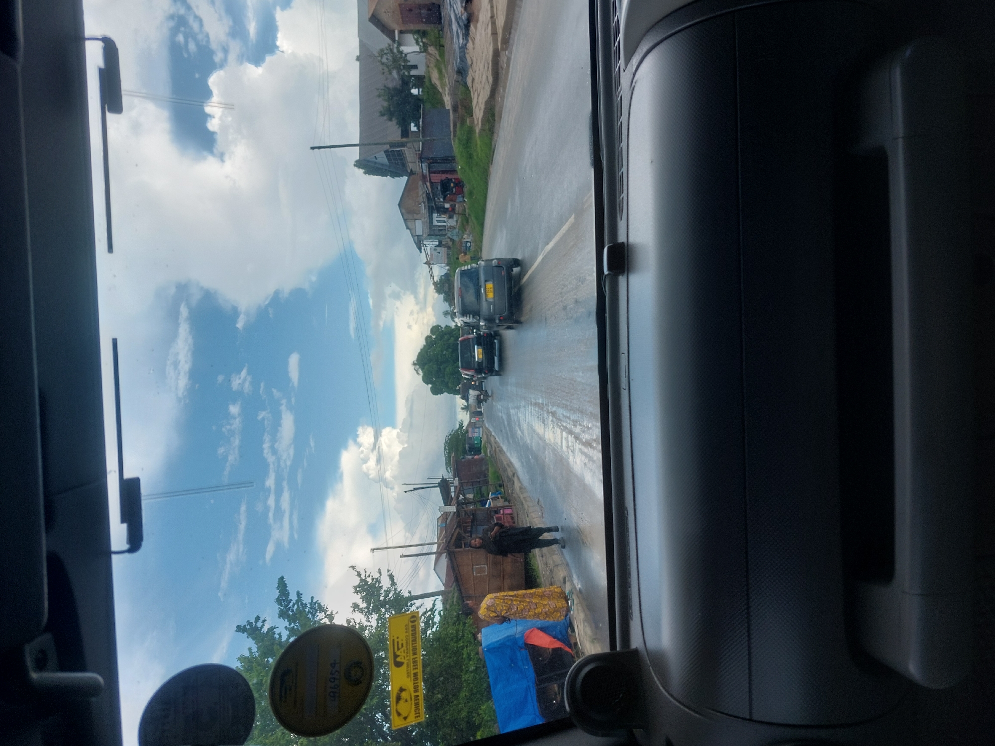 Traffic flows past person with blue tarp in Dar es-Salaam