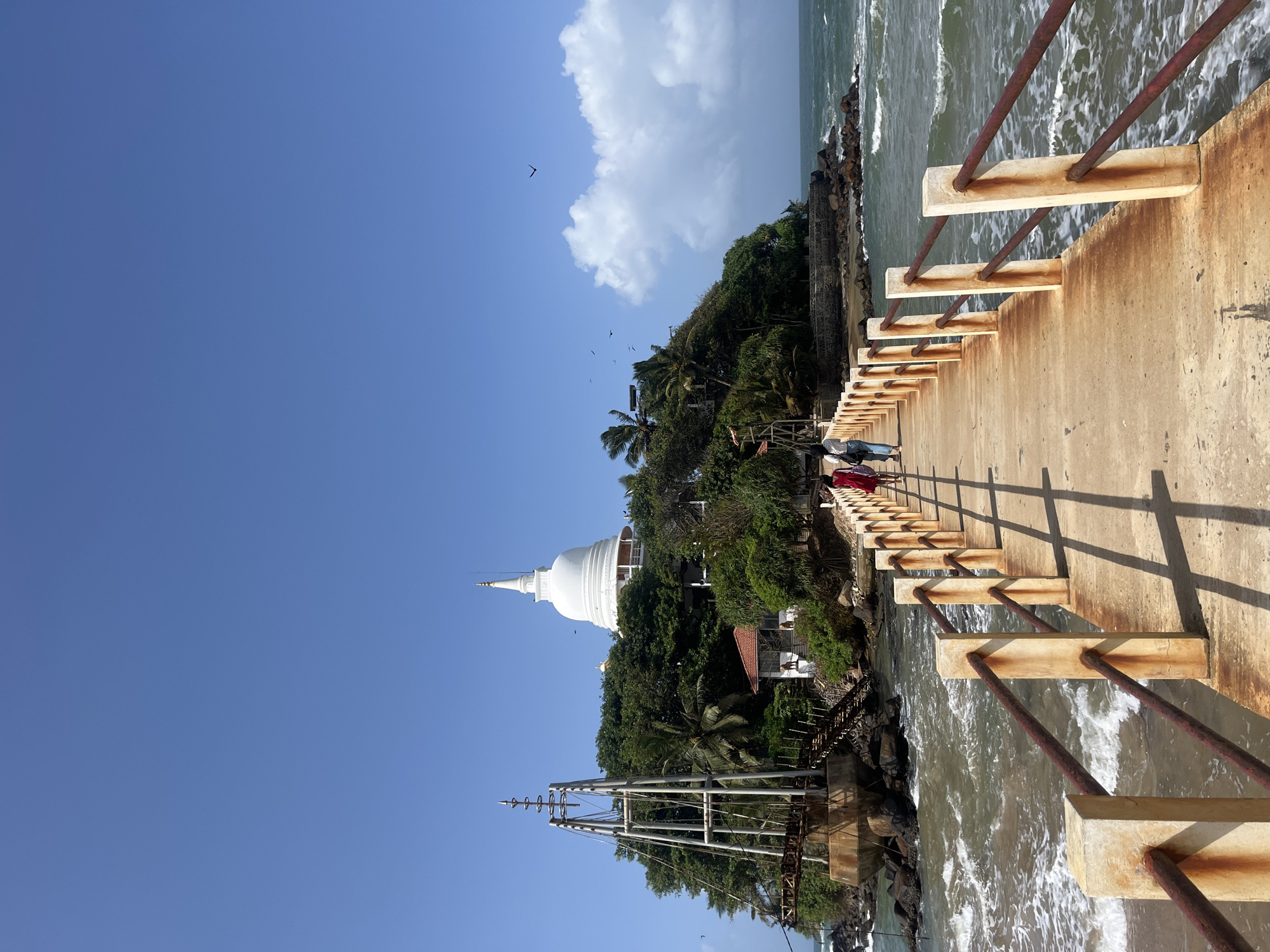 Rusting coastal structures and a stupa island in Walgama