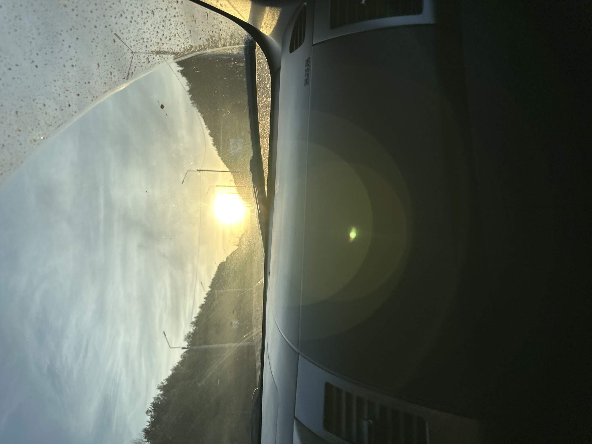 Vehicle travels rural road during sunset in Shud'ya, Russia