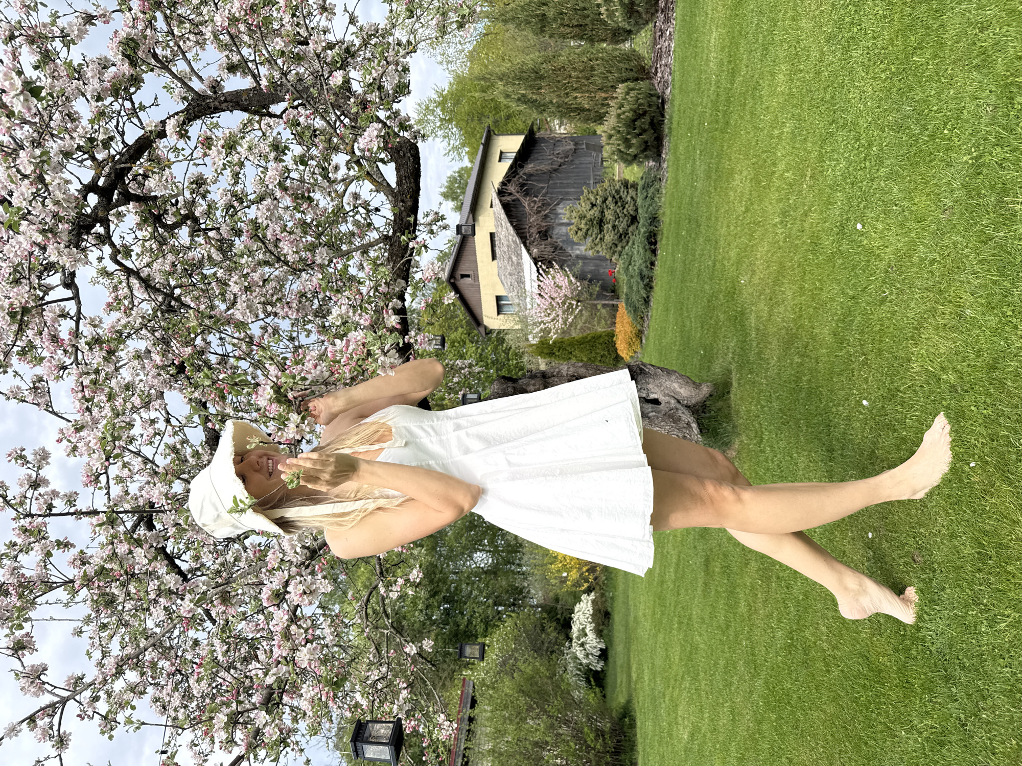 Woman enjoys spring afternoon among blooming trees in Latvia