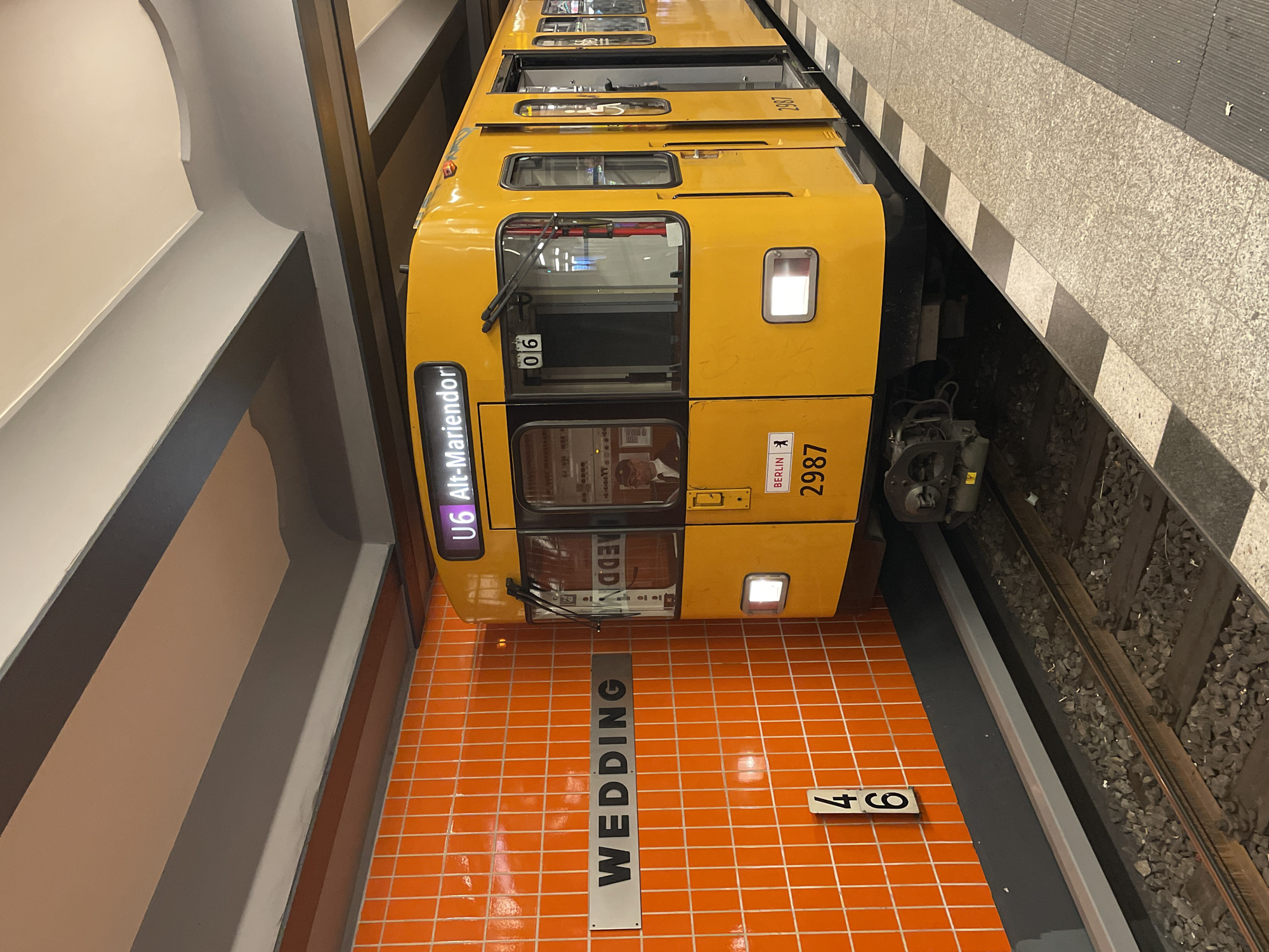 Yellow U6 subway train stops at Berlin station with passengers