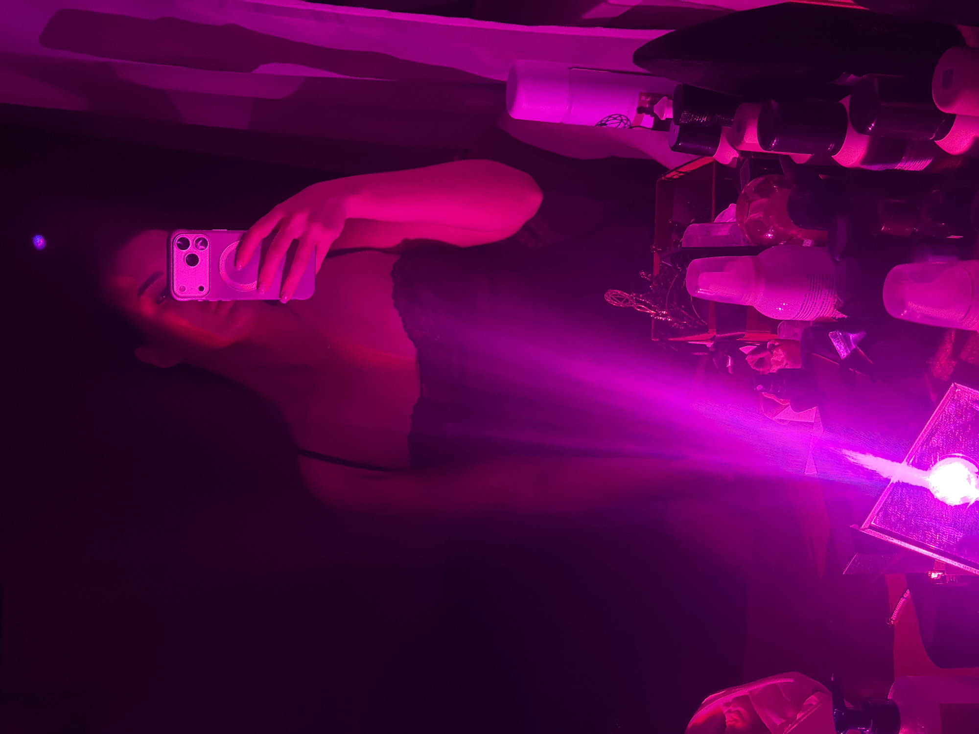 Woman takes selfies in pink-lit Moscow room