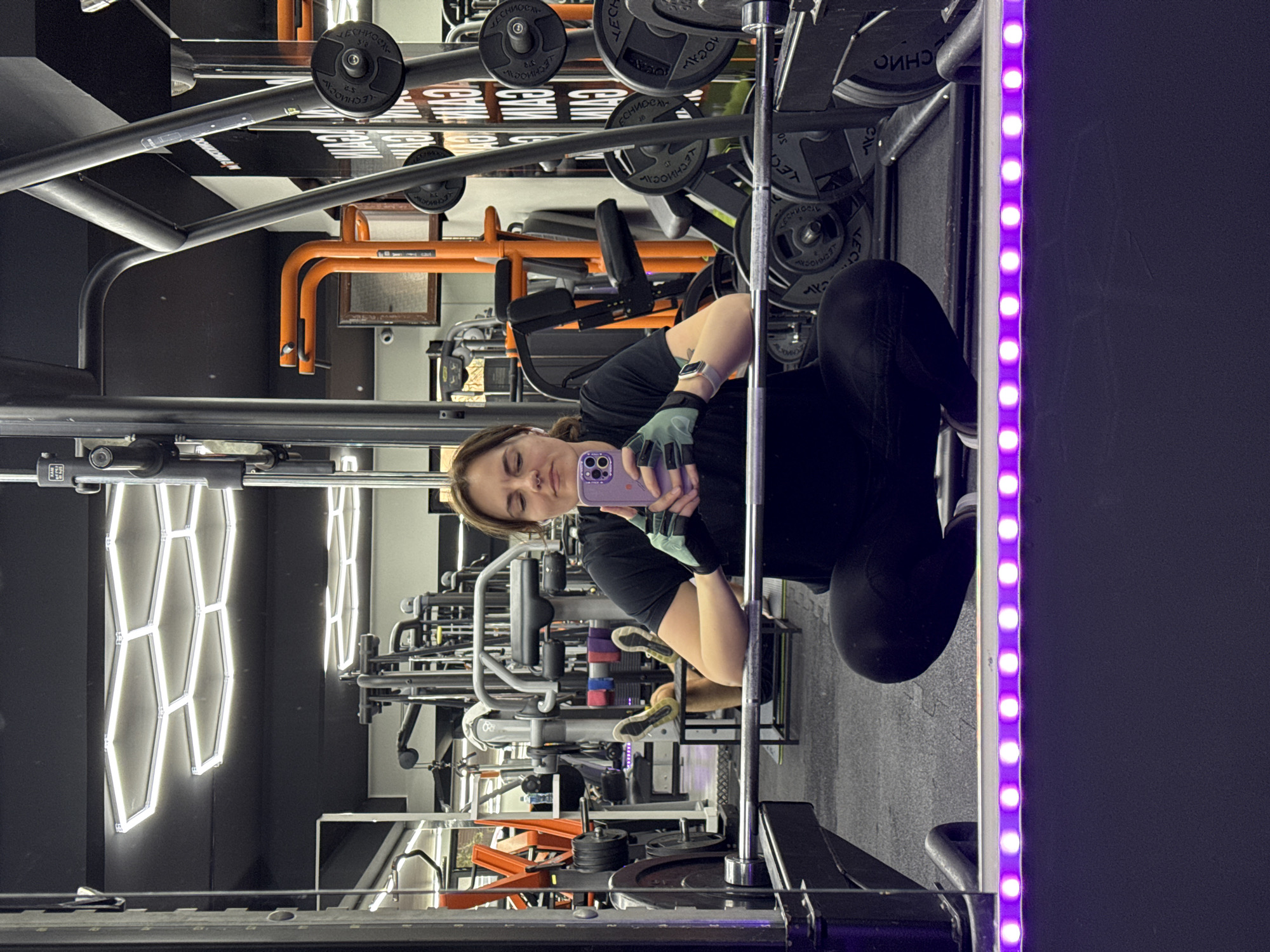 Person takes gym selfie with purple phone in Budva