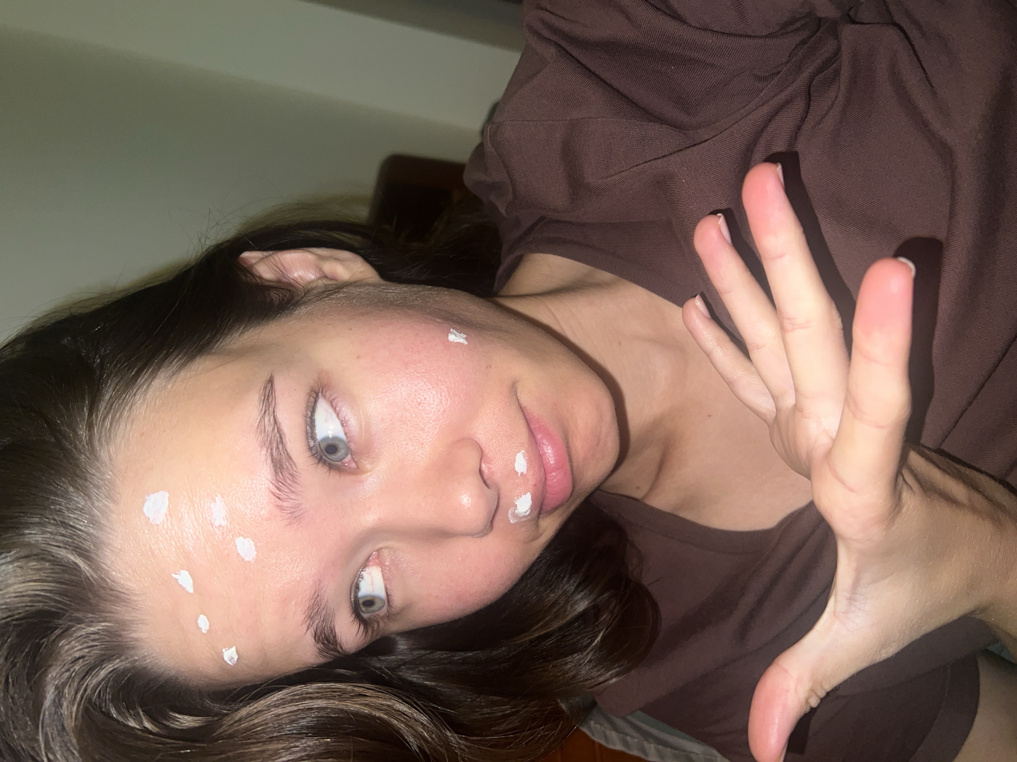 Woman applies skincare cream in Nha Trang indoor setting
