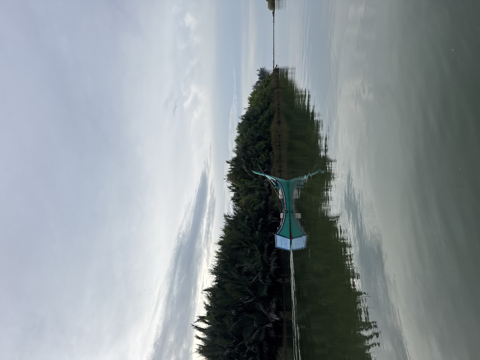 Decorated river boats navigate calm Indonesian waterways on a quiet morning