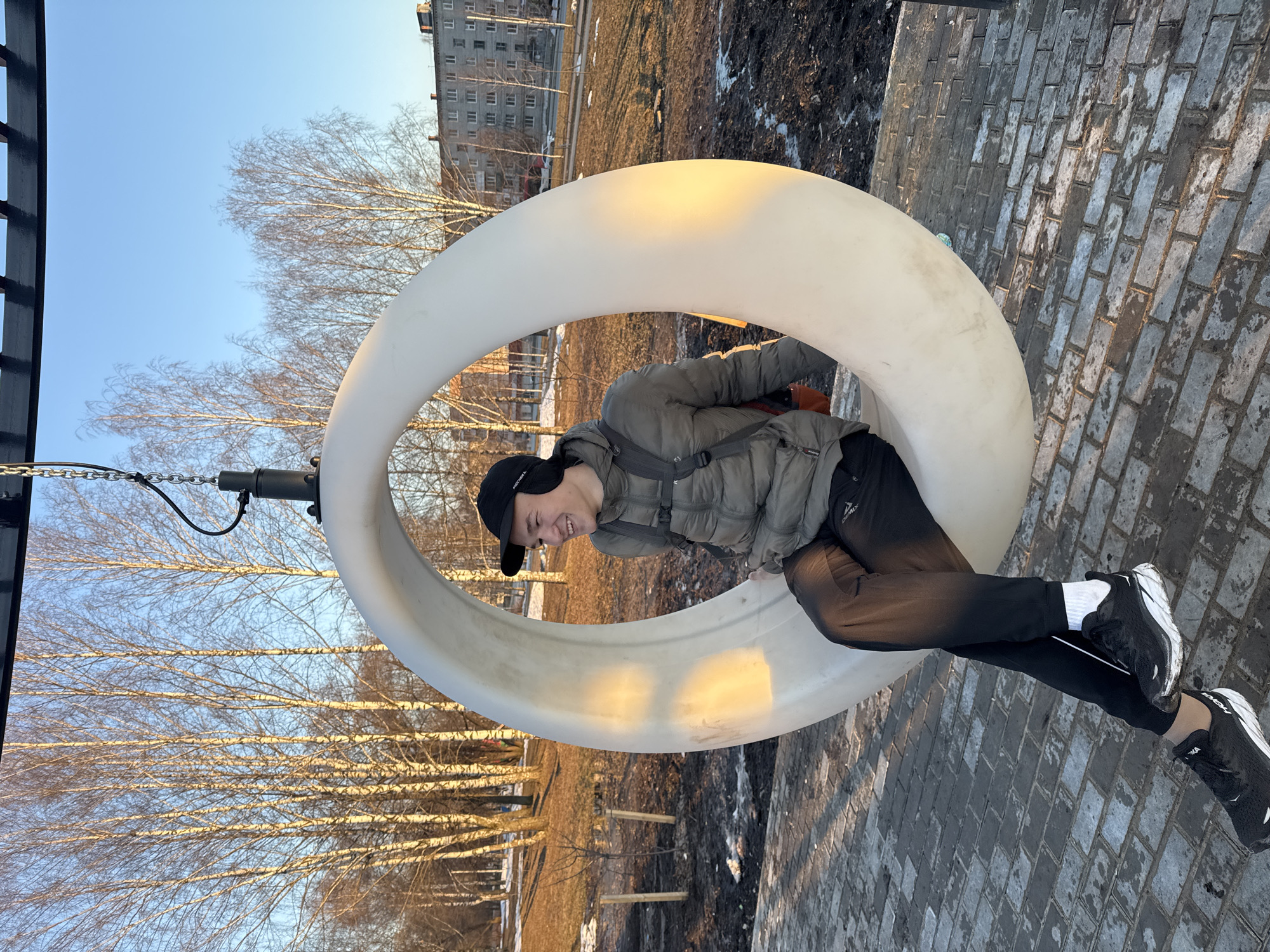 Young adults enjoy circular swings at Berezniki park playground