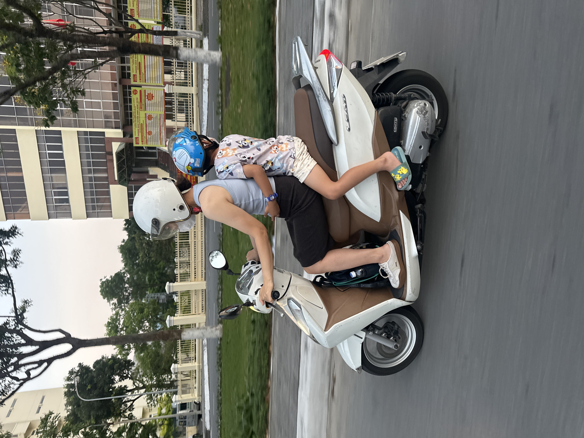 Adult and child ride scooter together in Đà Nẵng