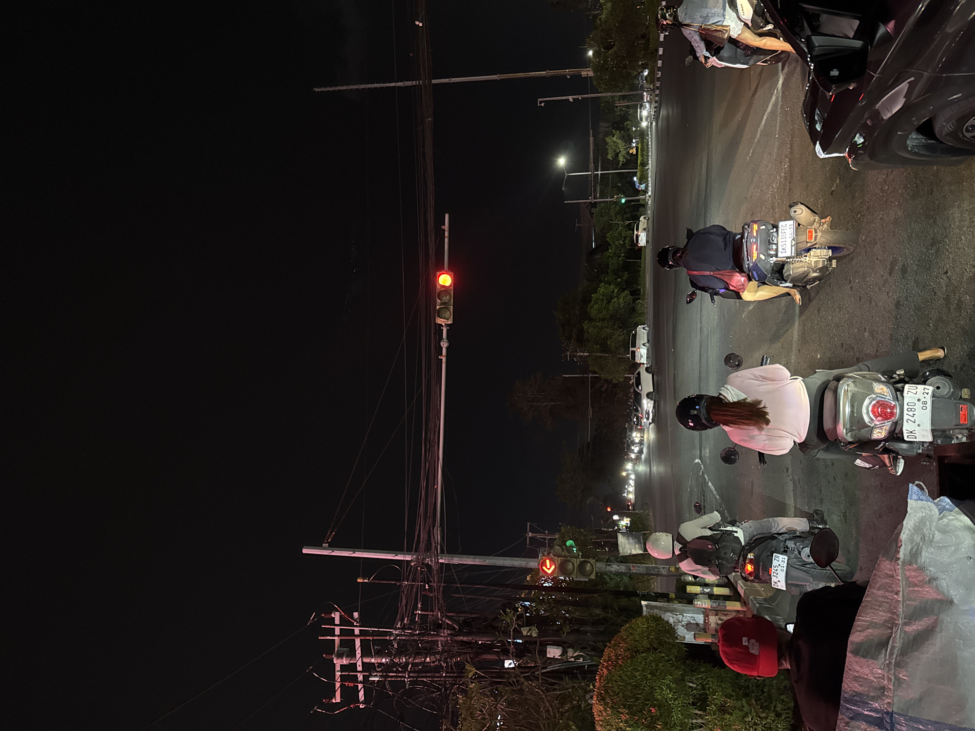 Late-night traffic and a neon party bus rolling through Kuta