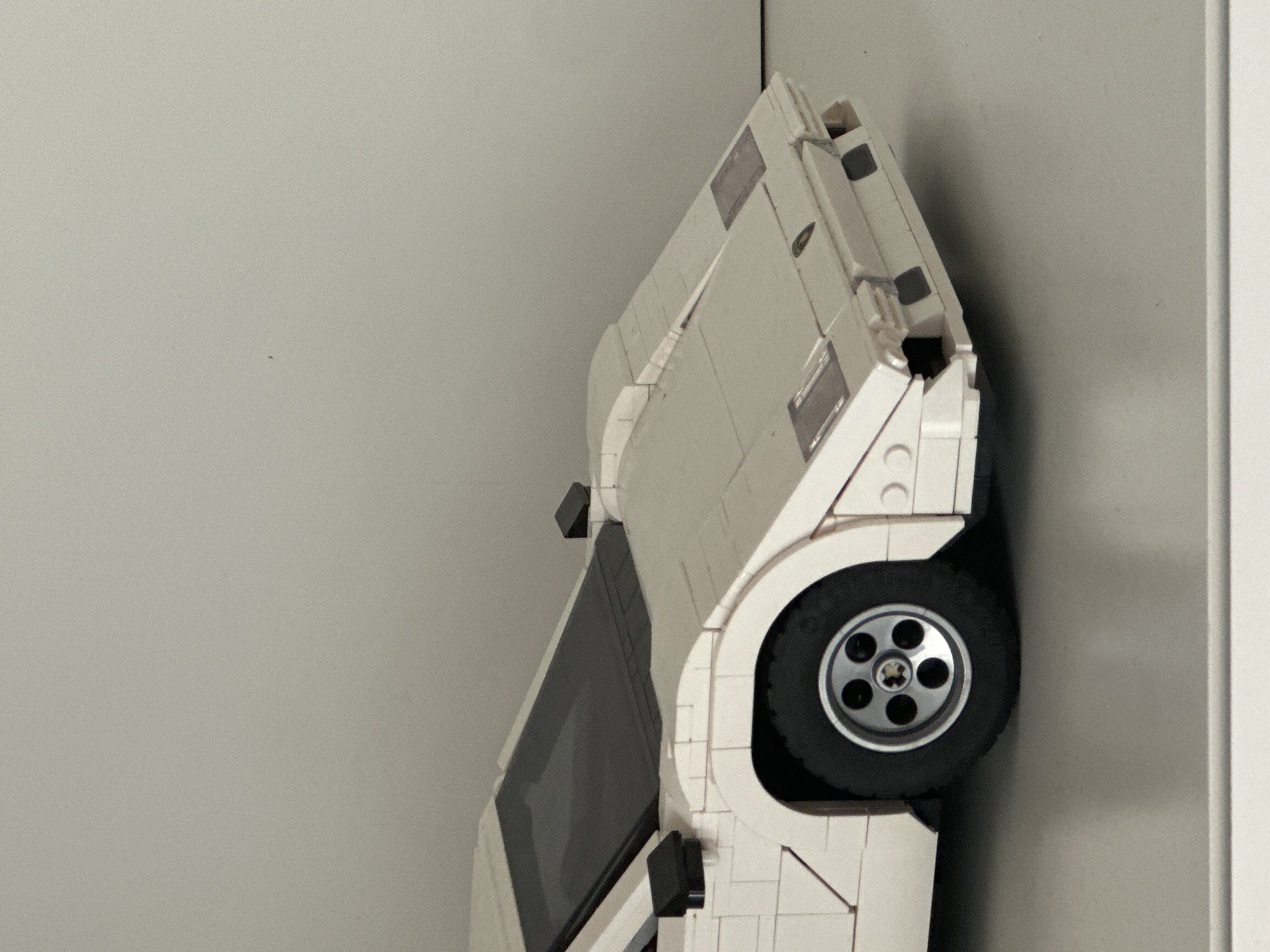 White LEGO-style vintage car model spotted upright in Milan